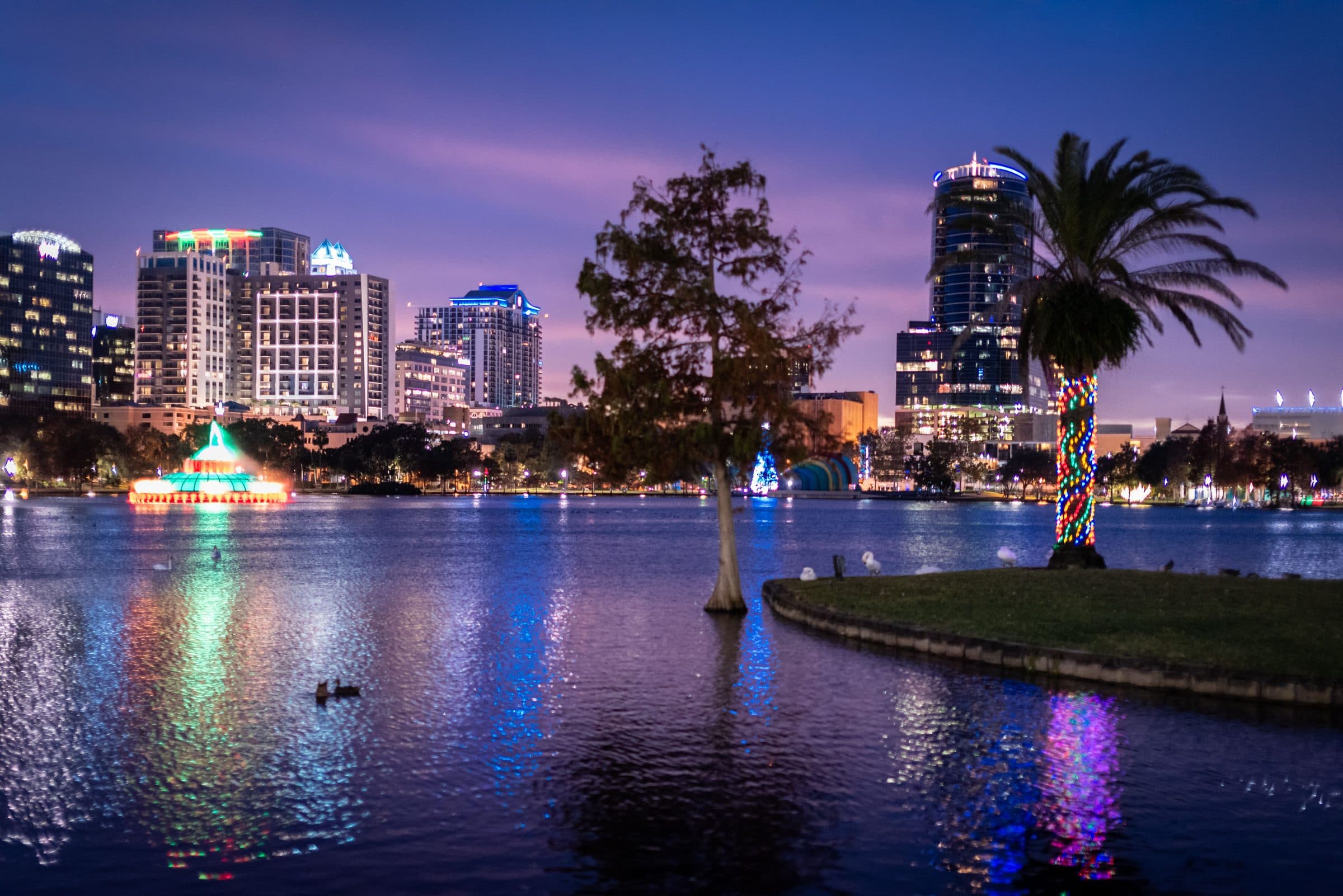 Prédios de Orlando refletidos nas águas do Lake Eola ao entardecer