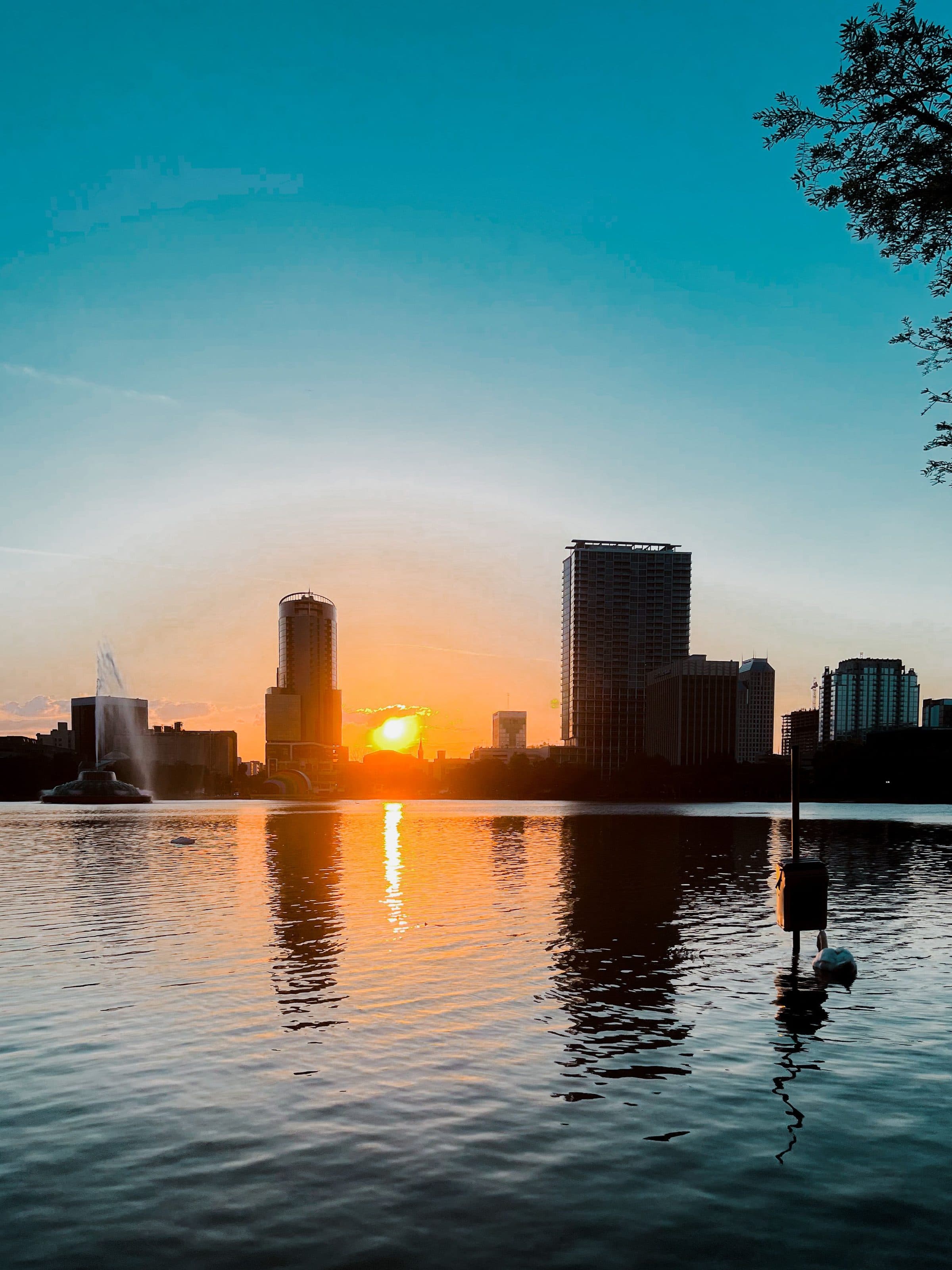 Prédios da cidade de Orlando refletidos no Lake Eola durante o pôr do sol