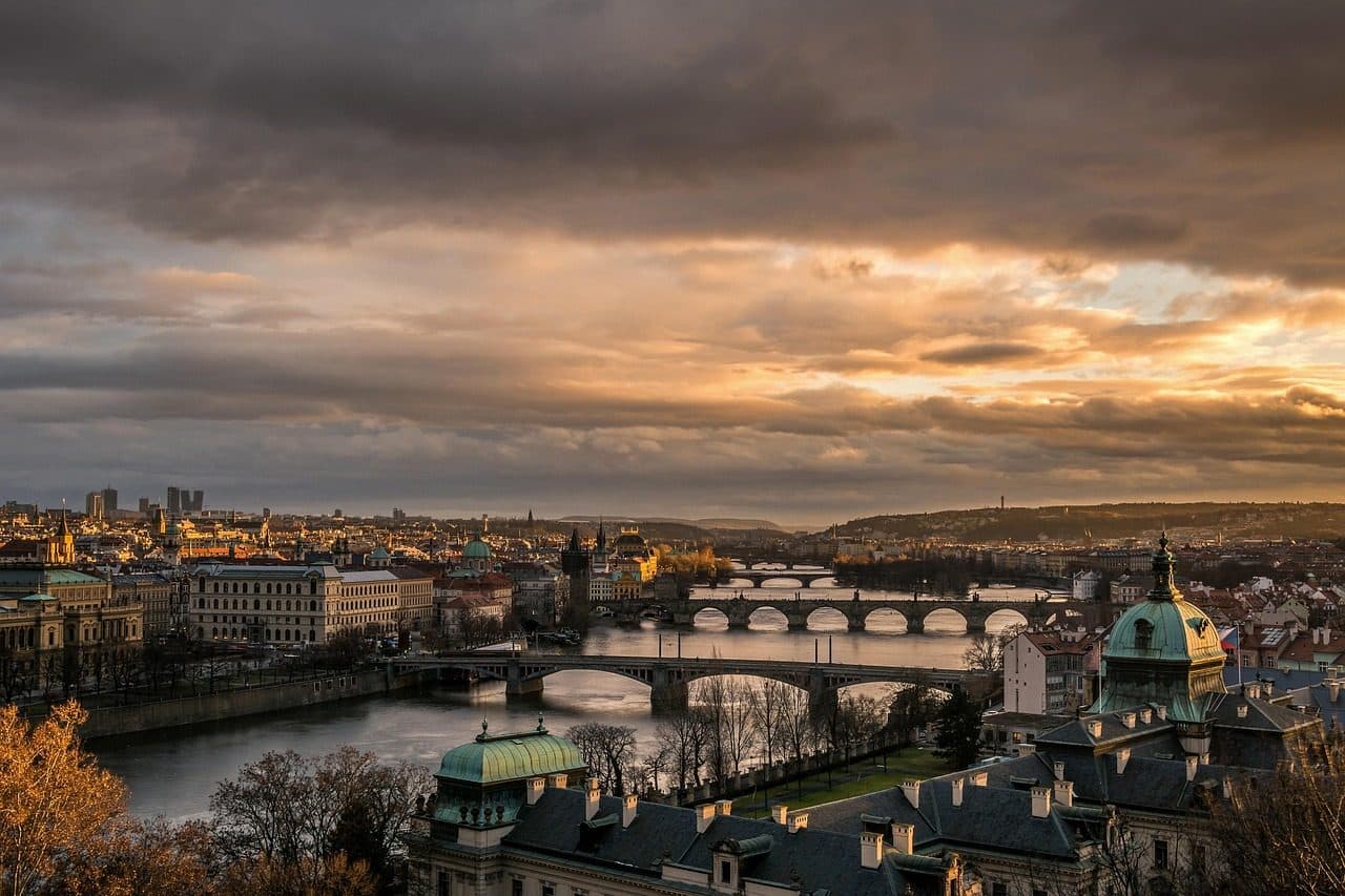 Vista panorâmica de Praga com a Charles Bridge sobre o rio durante o entardecer