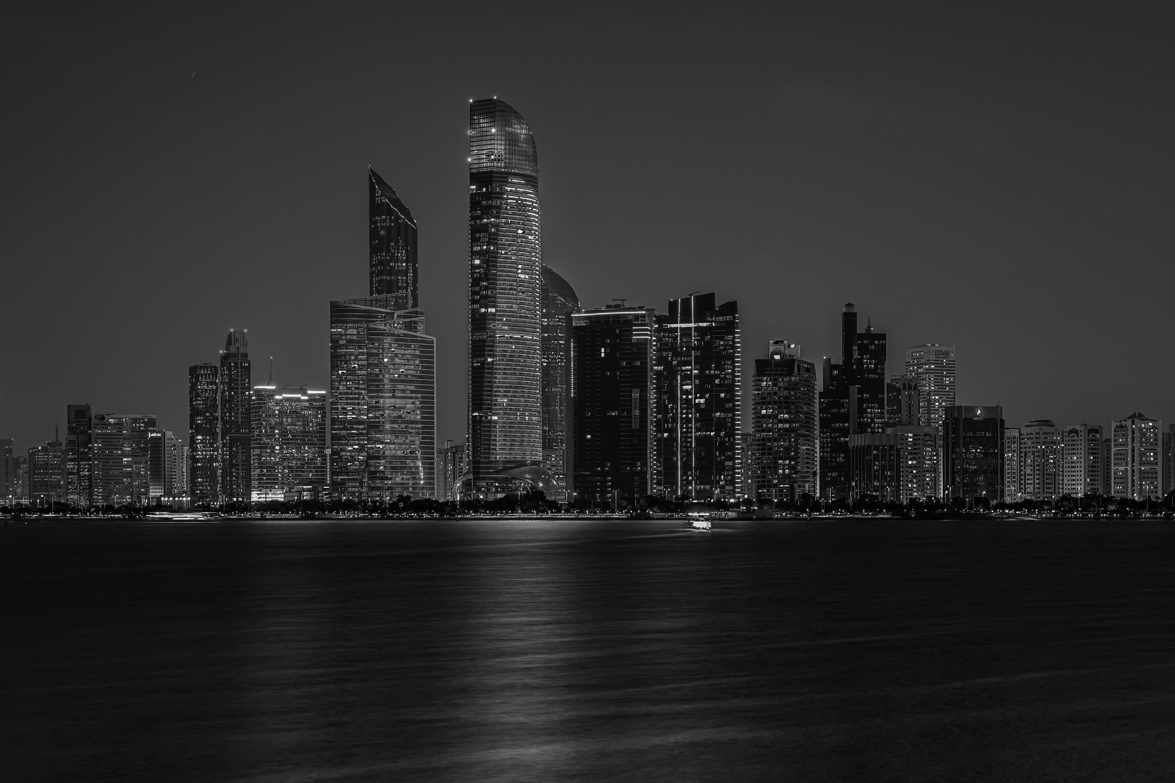 Vista noturna em preto e branco da silhueta urbana de Abu Dhabi