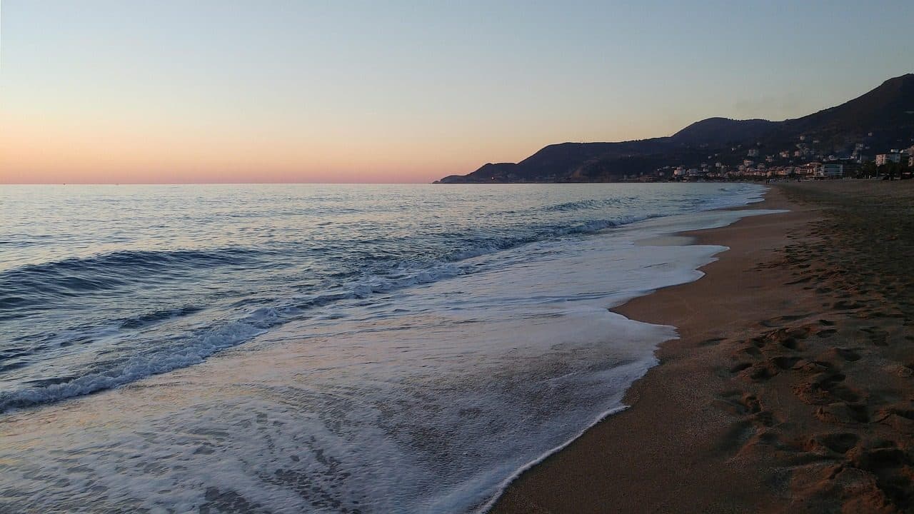 Praia e costa do Mar Mediterrâneo durante o pôr do sol em Alanya, Antalya