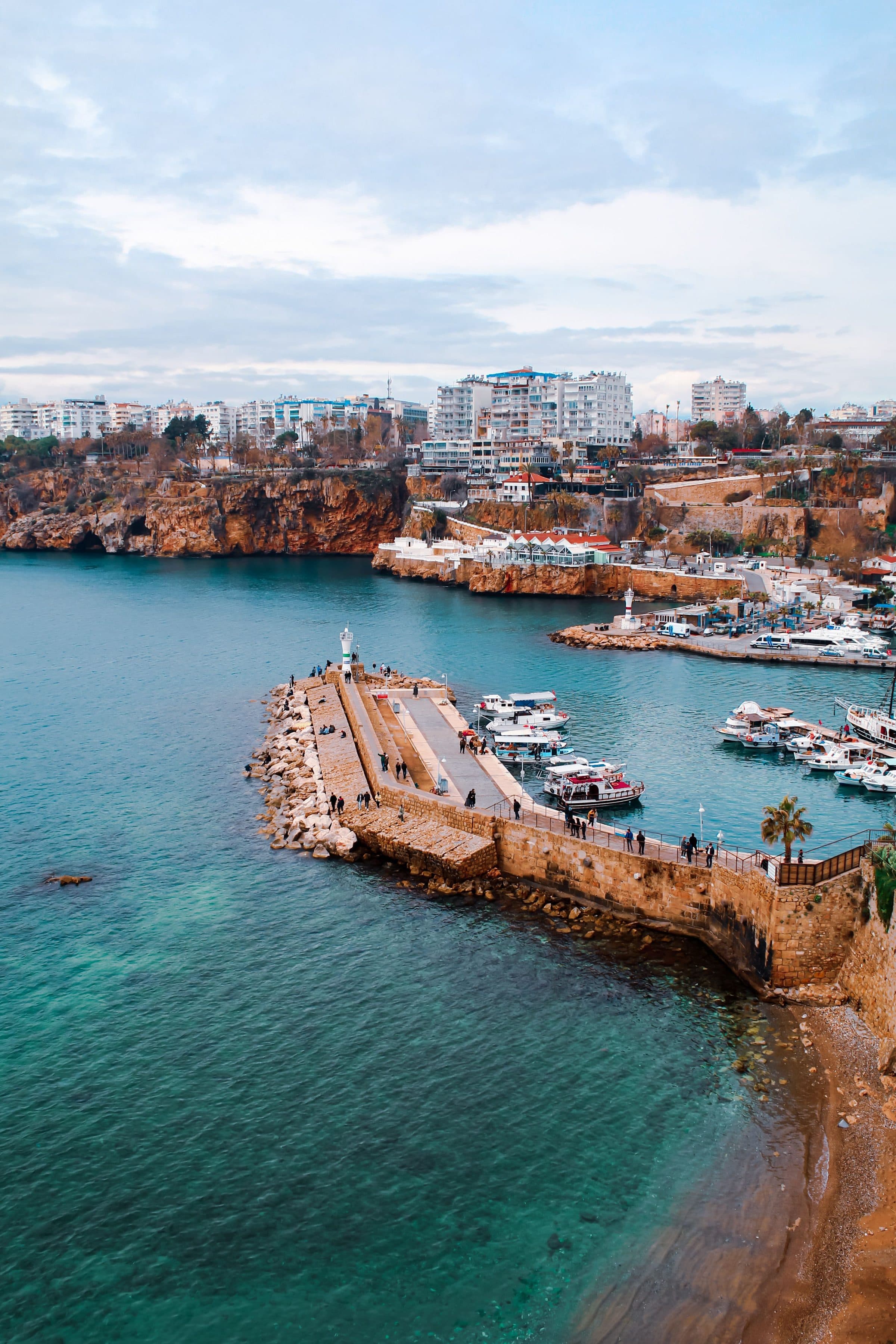 Vista aérea de uma marina na costa de Antalya, com o mar e a paisagem urbana