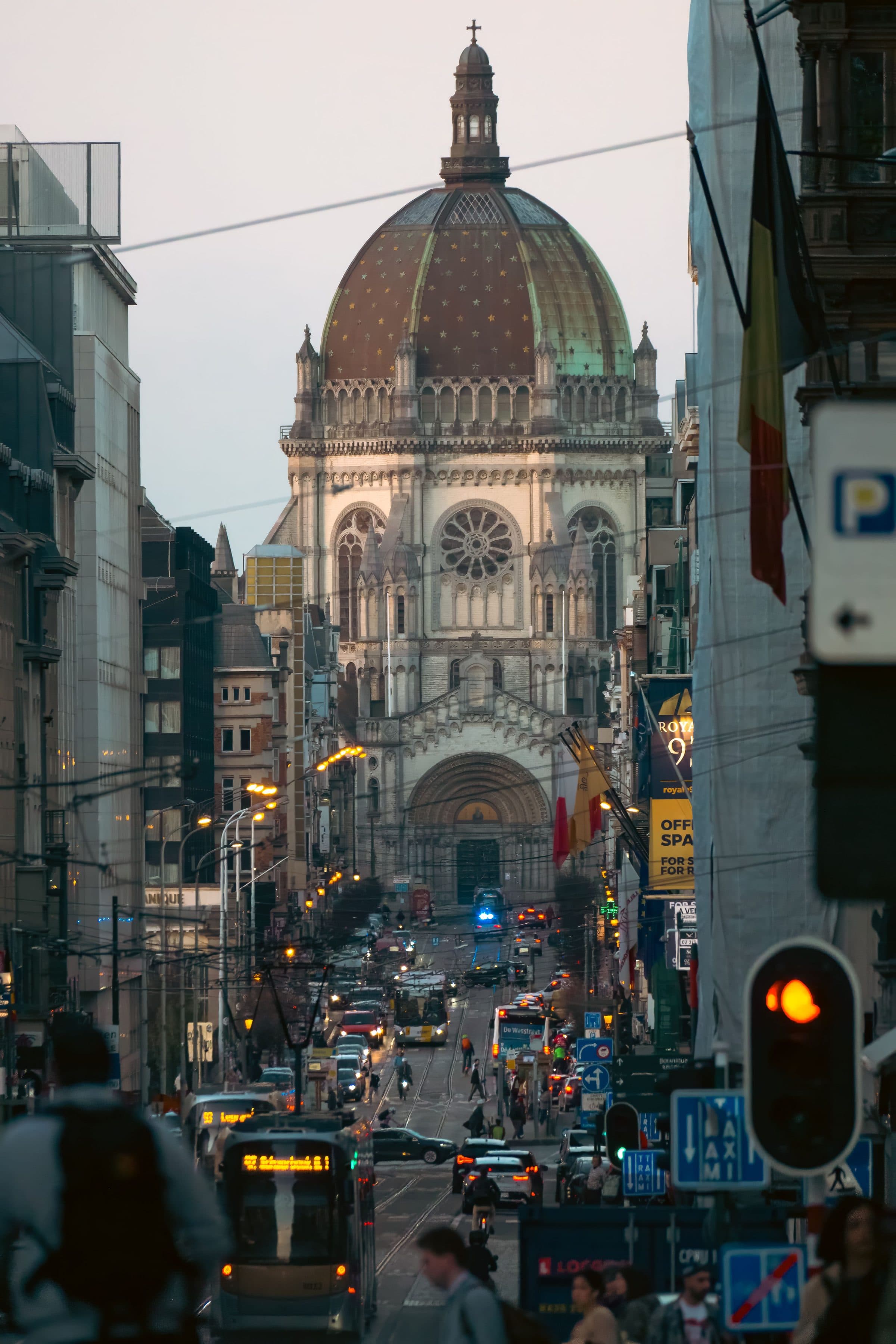 Rua movimentada em Bruxelas com a Church of St. John and St. Stephen ao fundo