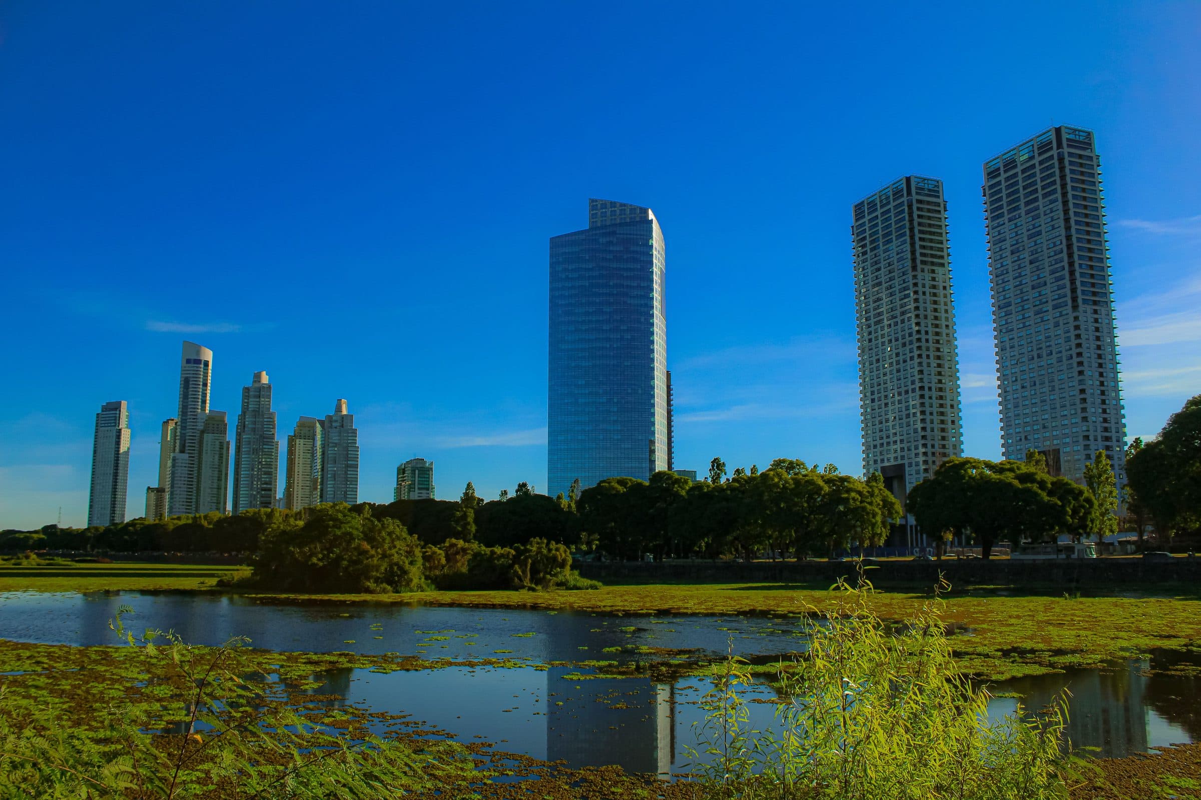 Arranha-céus de Buenos Aires refletidos na água de um lago em dia ensolarado