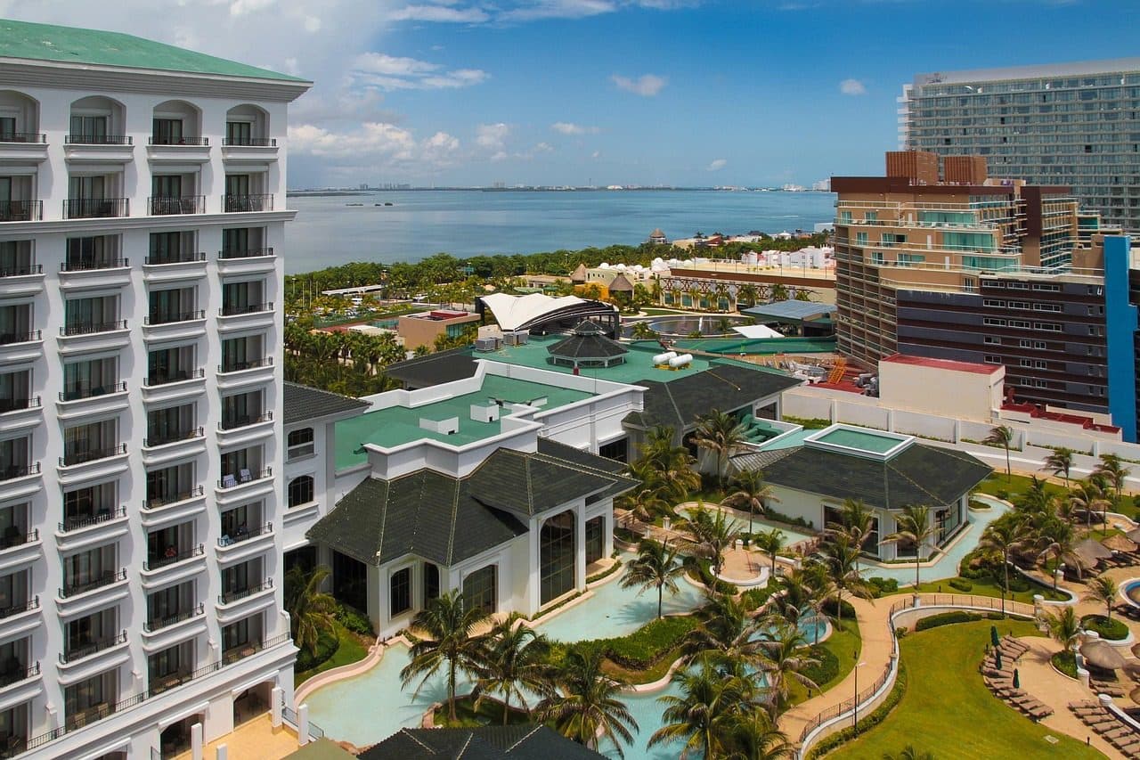 Vista da piscina de um hotel à beira-mar com a praia e edifícios em Cancún