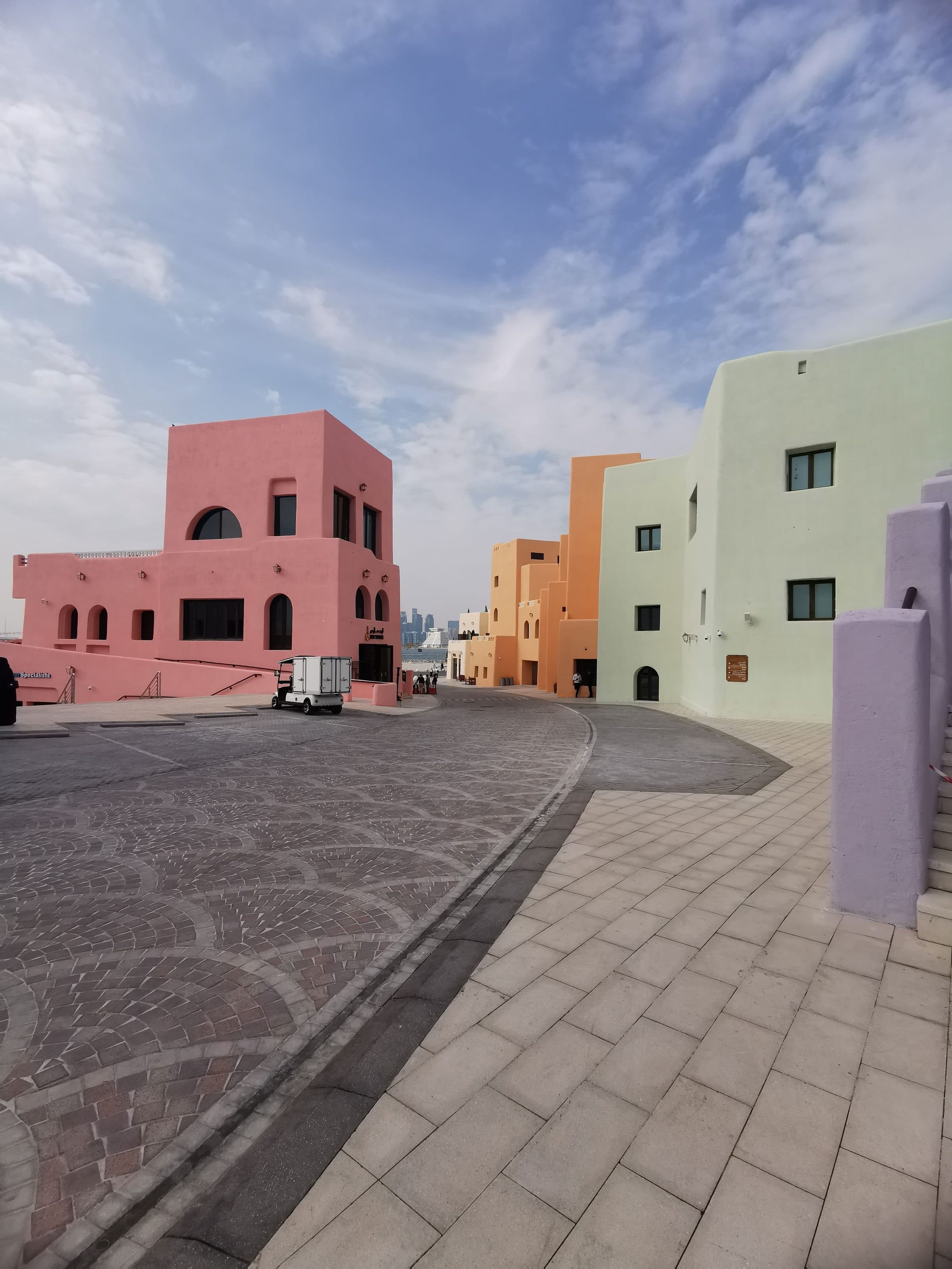 Edifícios em tons pastel ao longo de rua estreita no Old Doha Port, no Qatar