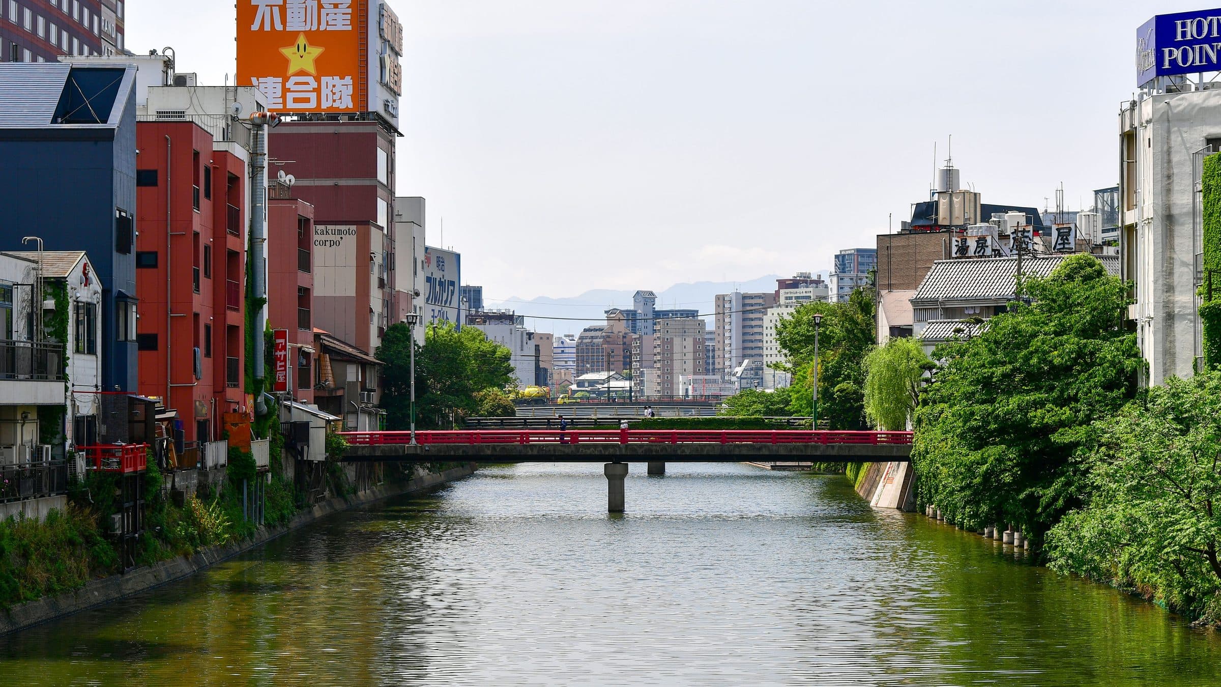 Vista do Rio Naka com ponte vermelha e edifícios ao redor em Fukuoka, no Japão