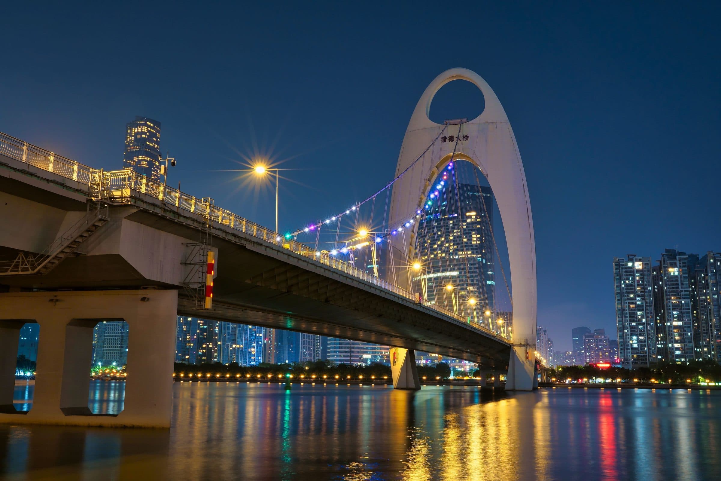 Vista noturna da Liede Bridge iluminada com o horizonte moderno de Guangzhou