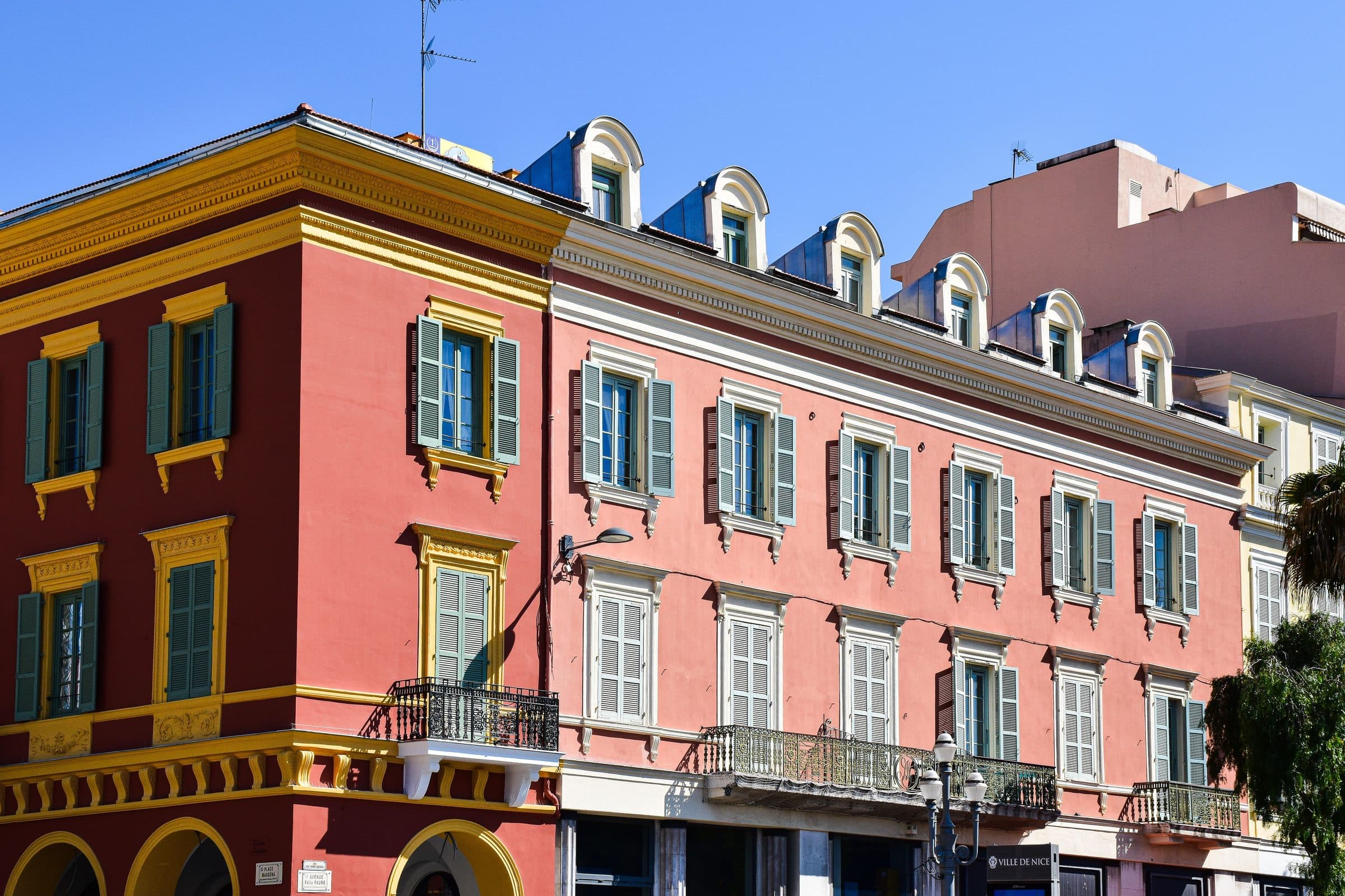 Edifício de arquitetura clássica francesa com fachadas coloridas em Nice, França