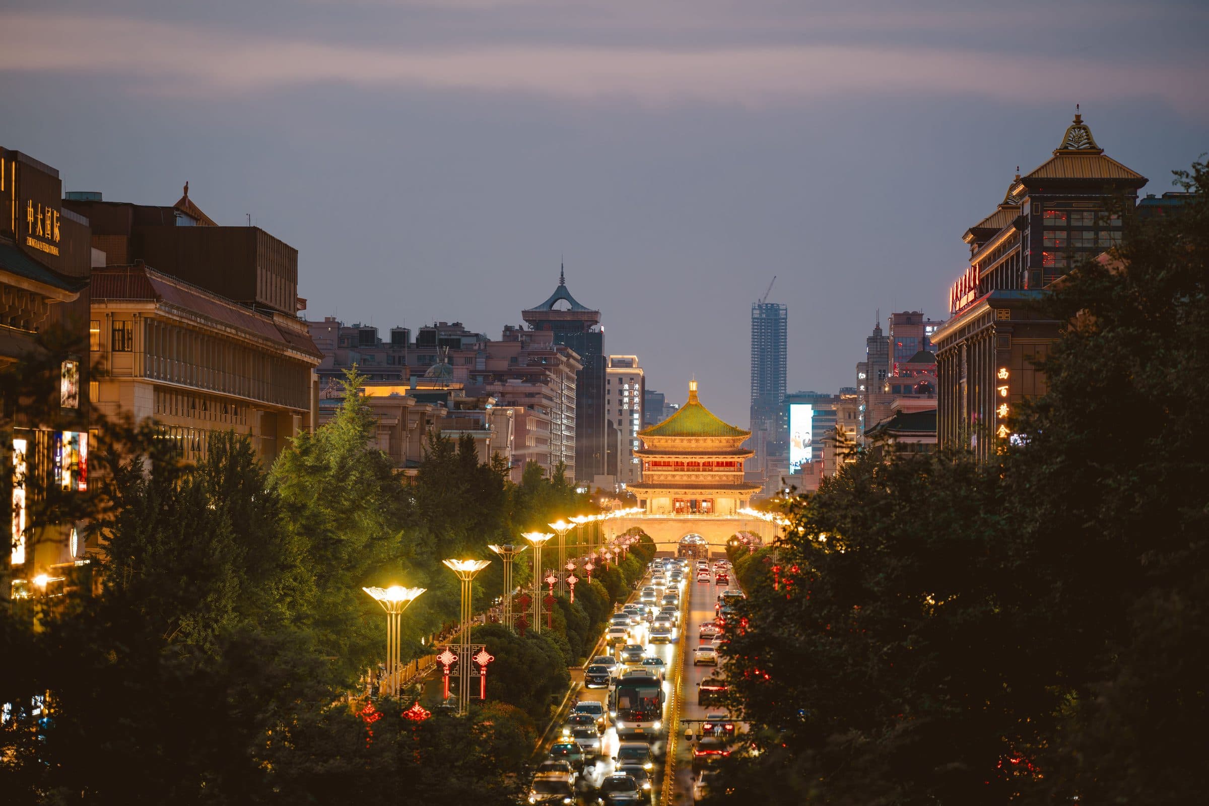 Vista noturna da Xi'an Bell Tower iluminada e ruas movimentadas ao redor