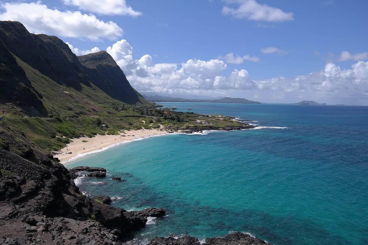 Praia ensolarada em Honolulu, na ilha de Oahu, com mar azul do Oceano Pacífico