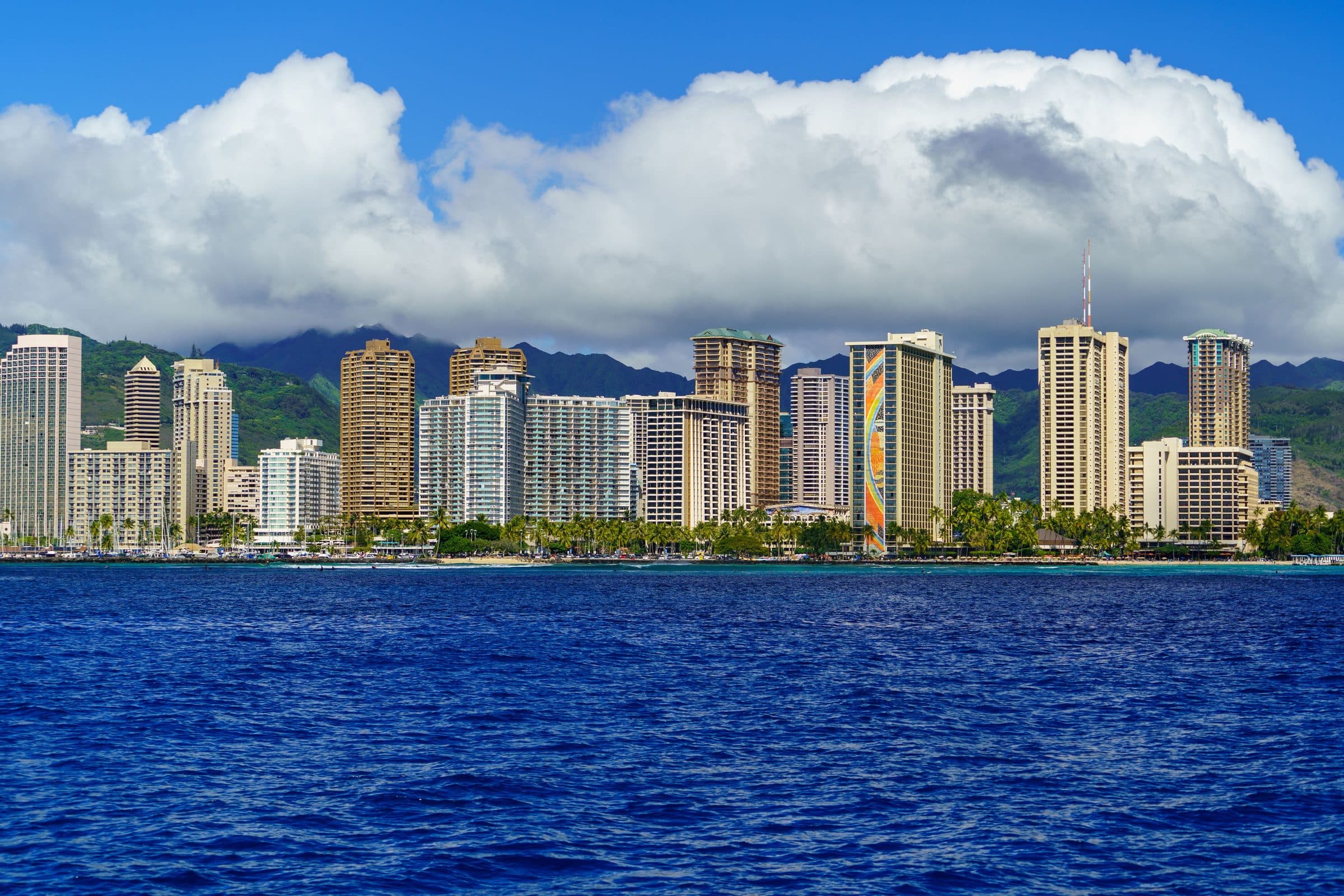 Vista dos prédios de Honolulu com o oceano e montanhas ao fundo