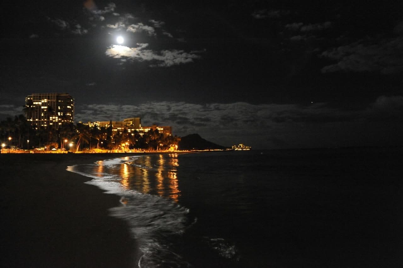 Vista noturna da praia de Waikiki com o Diamond Head ao fundo