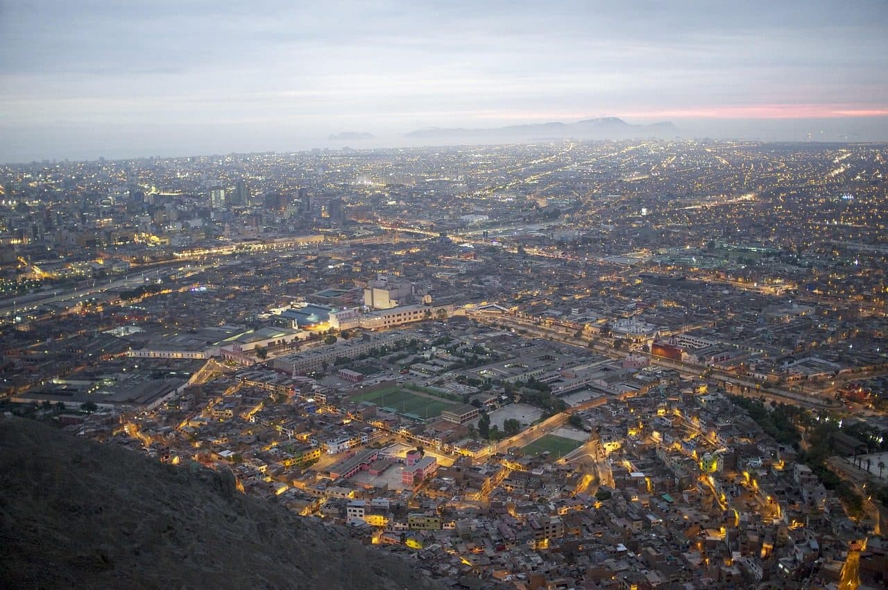 Paisagem urbana de Lima no Peru ao pôr do sol com névoa e o Cerro San Cristóbal