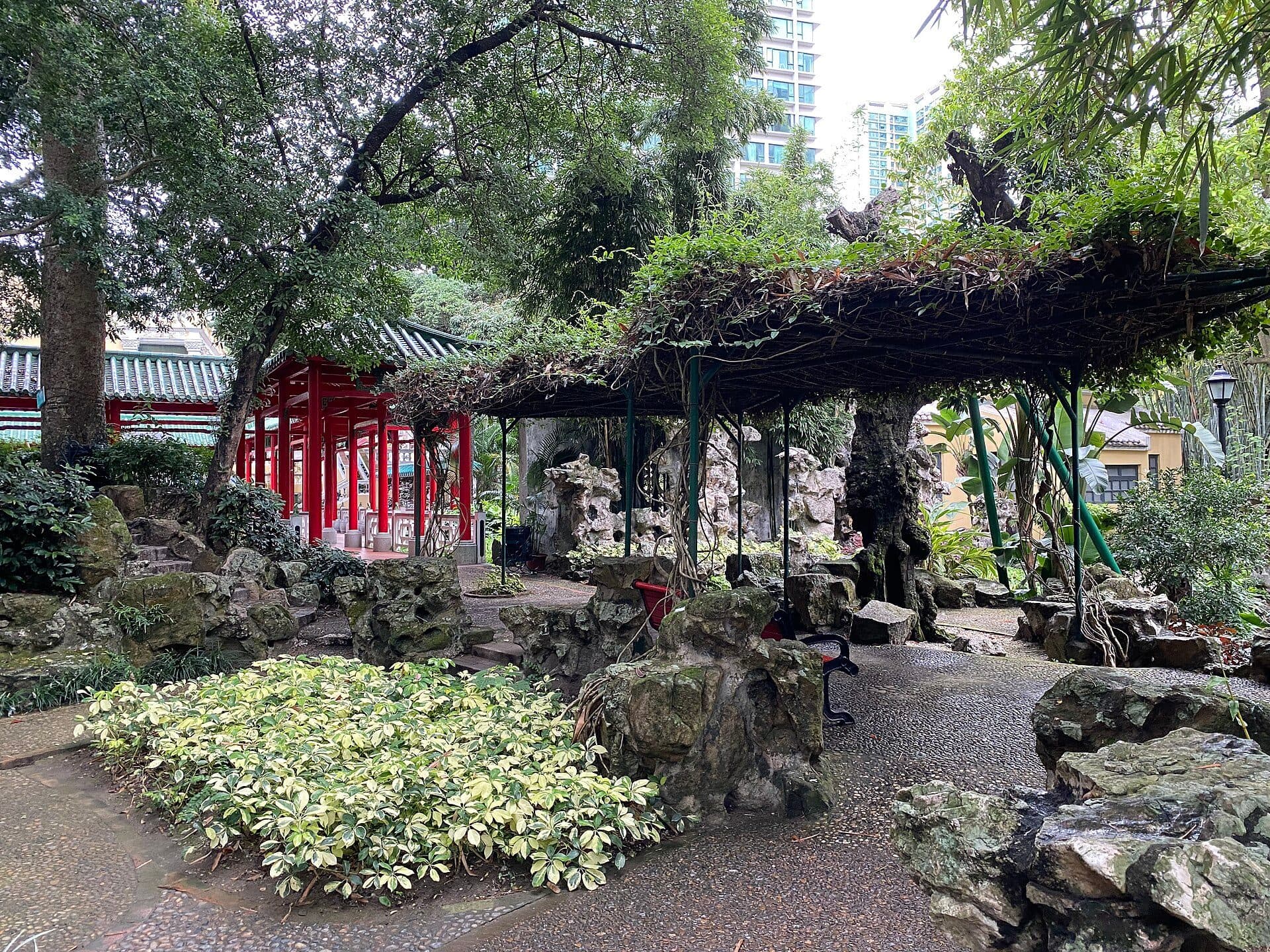 Vista da vegetação e da arquitetura tradicional no Jardim Lou Lim Ioc