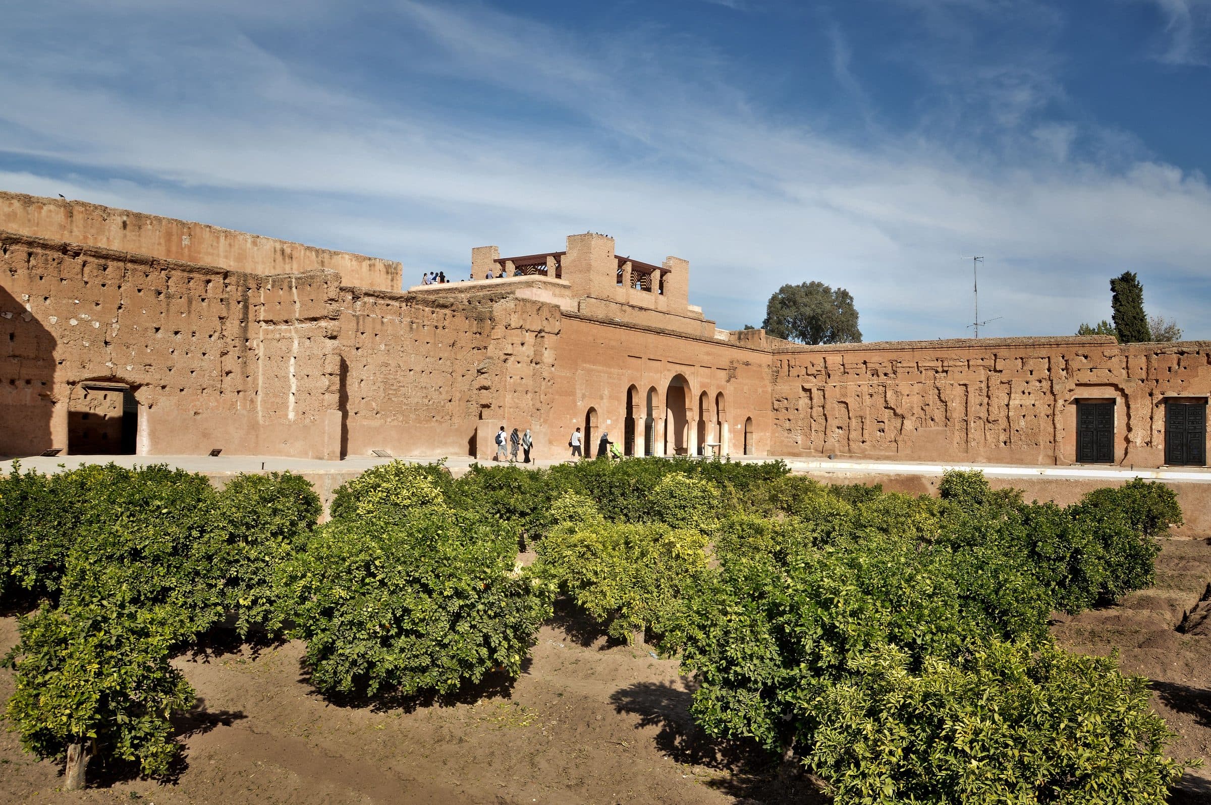 Muralhas vermelhas históricas e jardins sob céu azul em Marrakech, Marrocos
