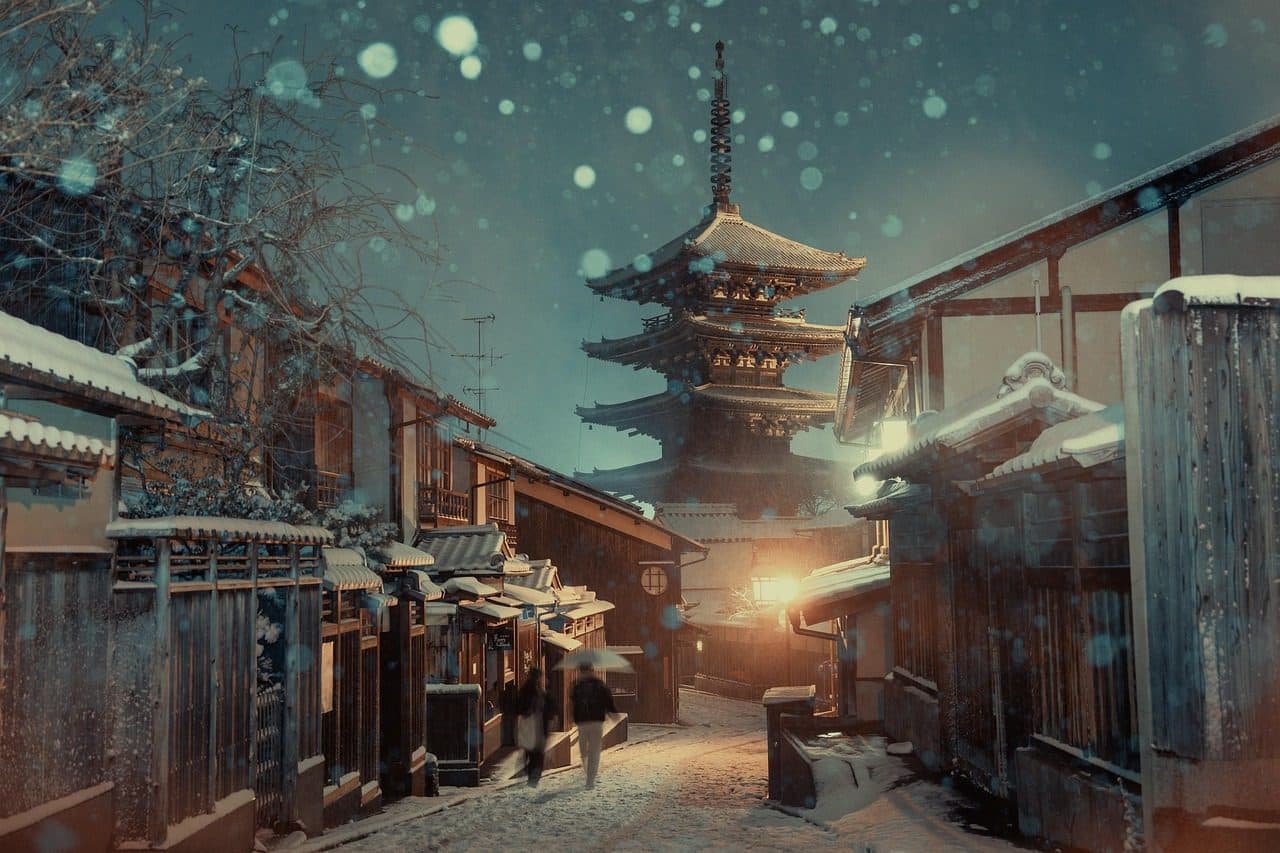 Vista noturna de um casal na cidade histórica de Kyoto sob a neve de inverno