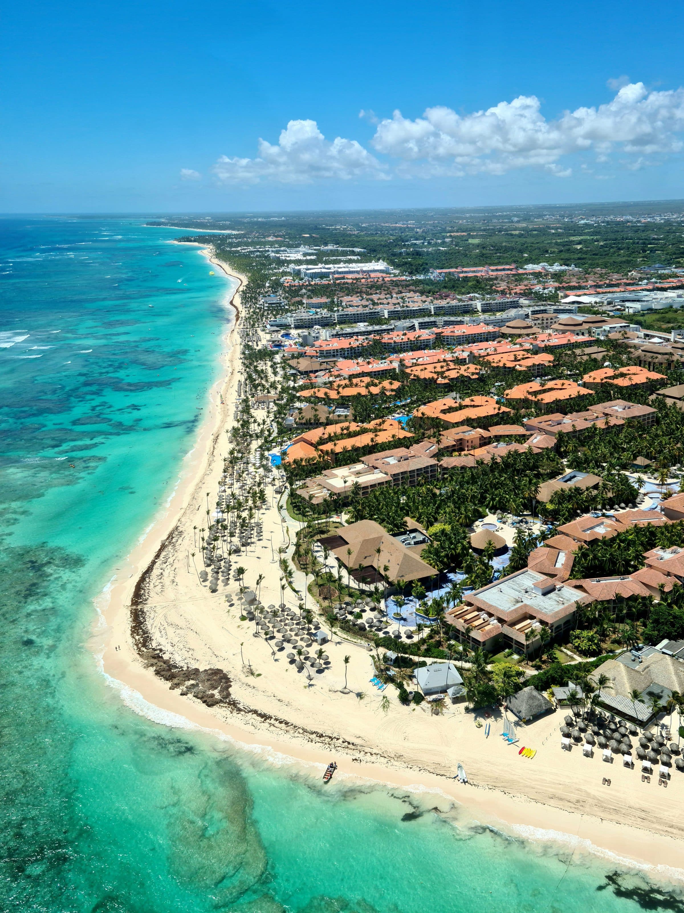 Vista aérea do litoral de Punta Cana com mar azul-turquesa e resorts na orla
