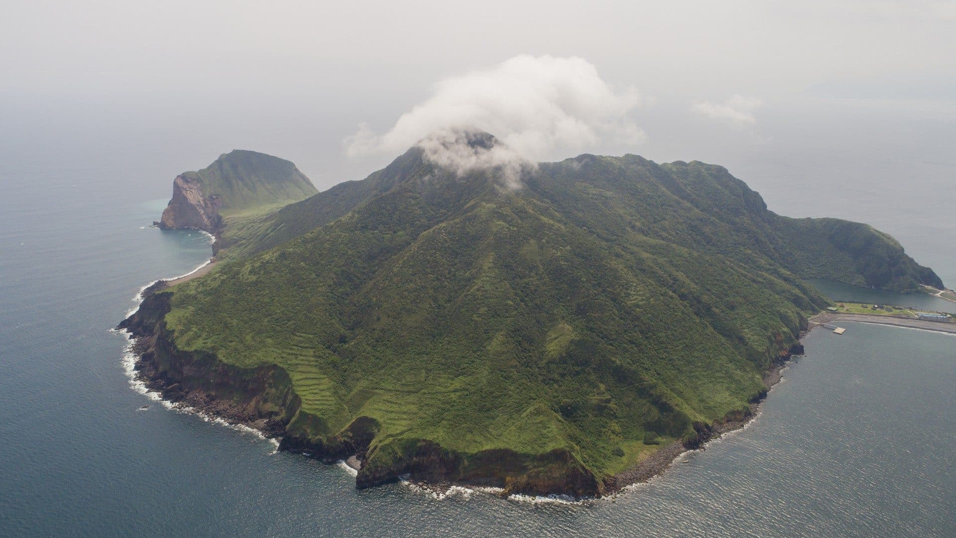 Nuvem cobrindo o topo da Ilha Guishan no horizonte sobre o mar.