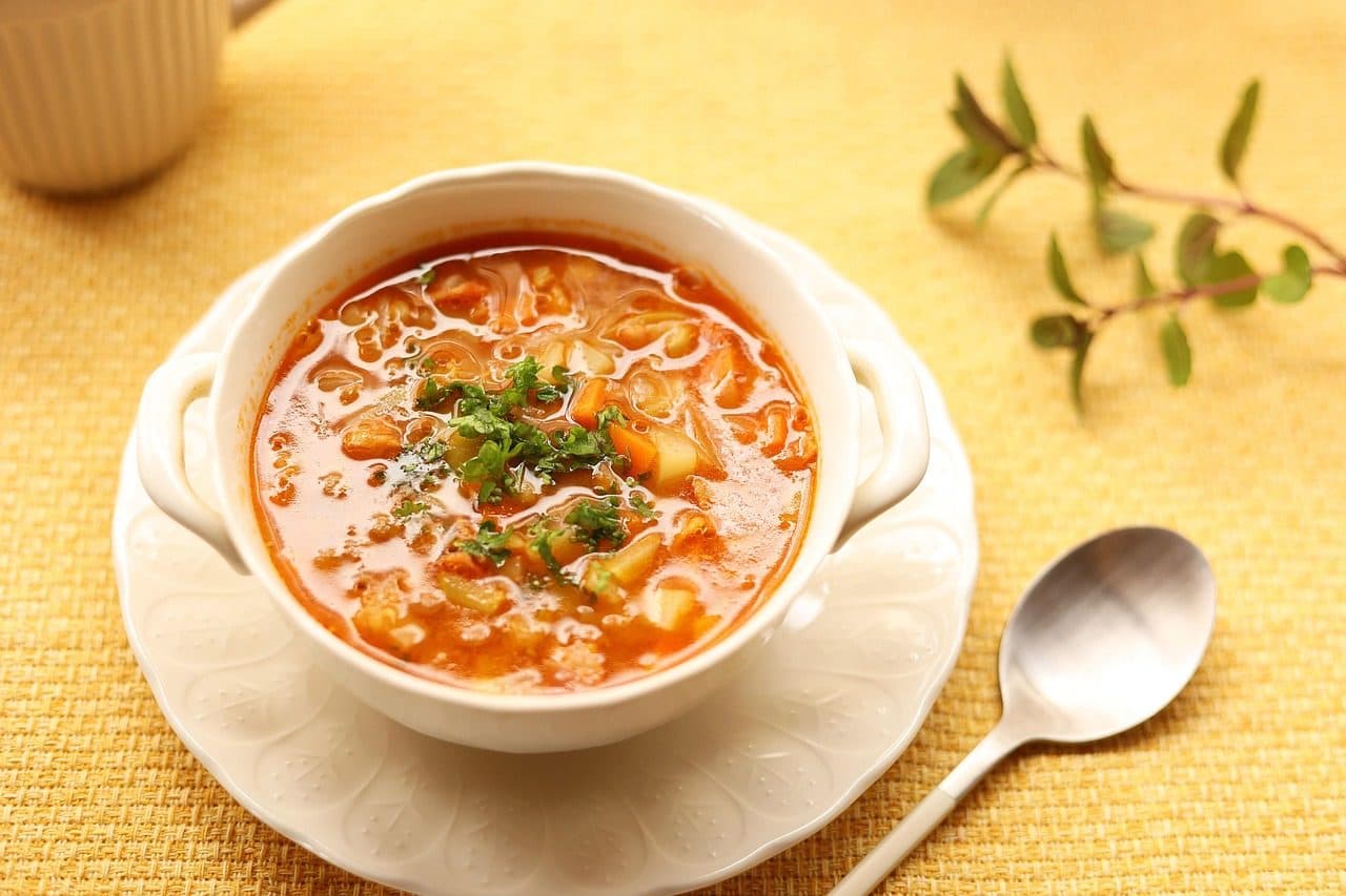 Prato de sopa de legumes tipo minestrone com caldo de tomate, grãos e ervas frescas