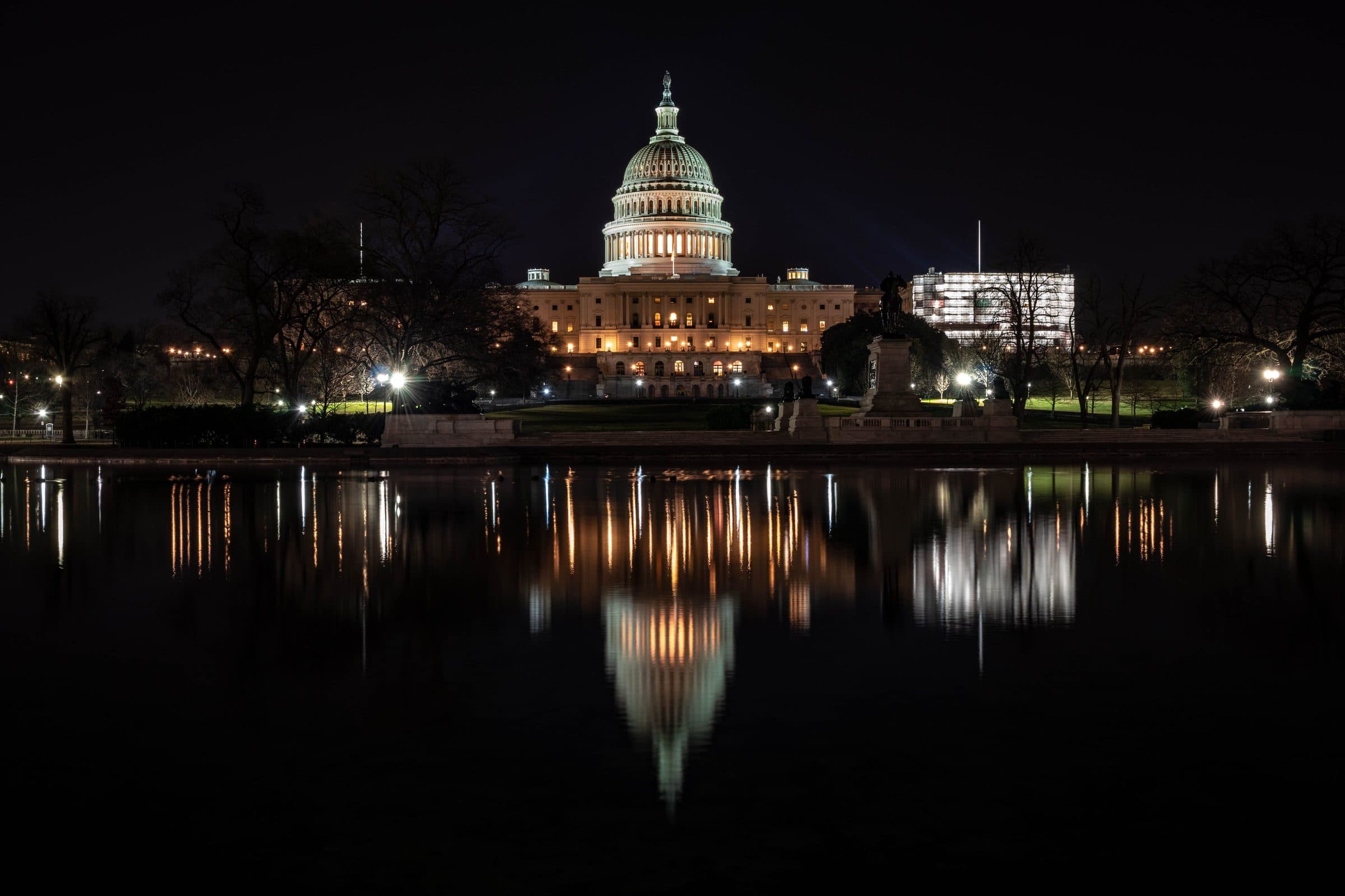 Capitólio dos Estados Unidos iluminado à noite e seu reflexo em Washington, D.C.
