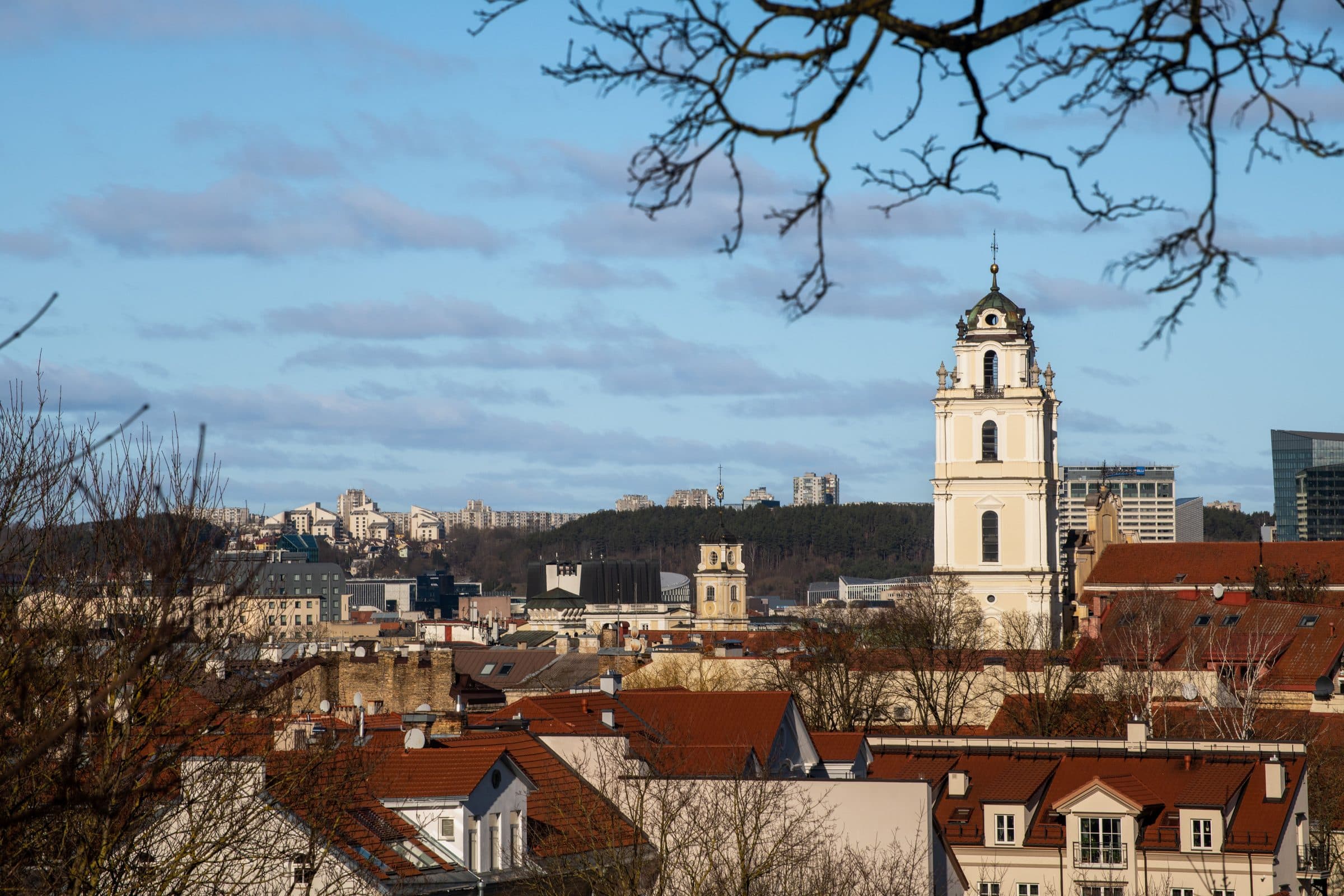 Vista da cidade de Vilnius com arquitetura histórica e uma torre de igreja sob céu limpo