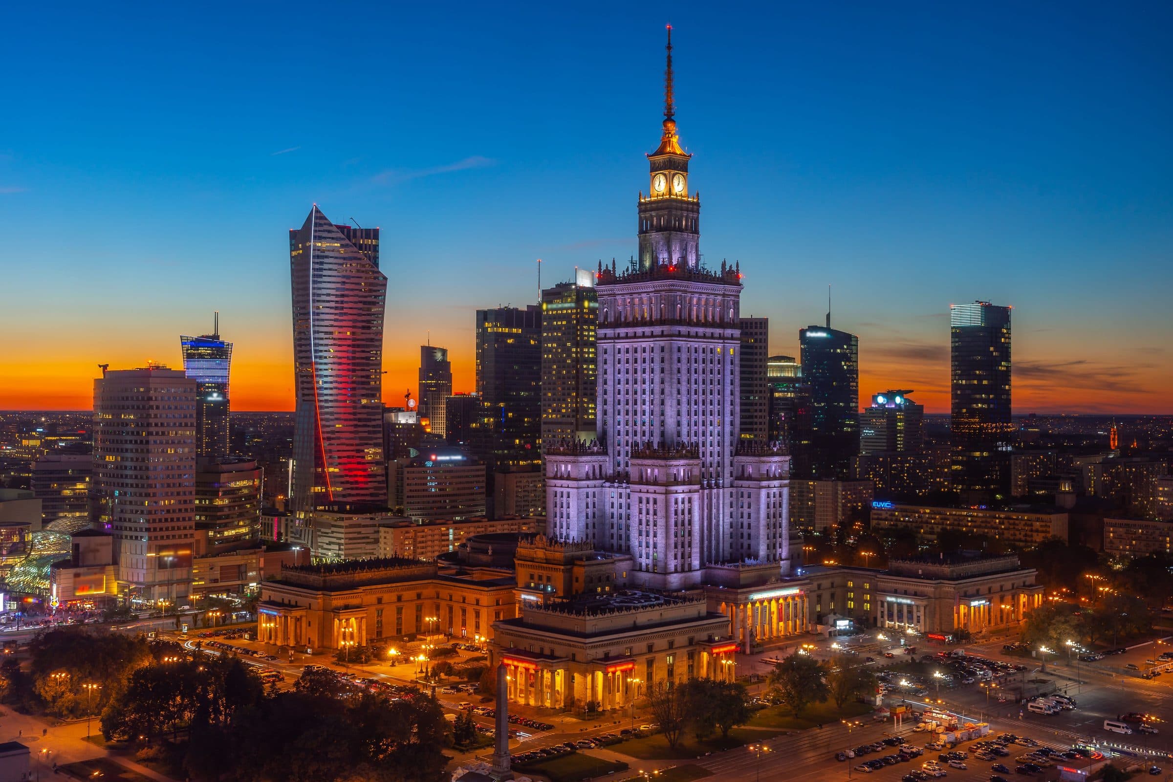 Vista aérea de Varsóvia ao anoitecer com o Palácio da Cultura e Ciência iluminado