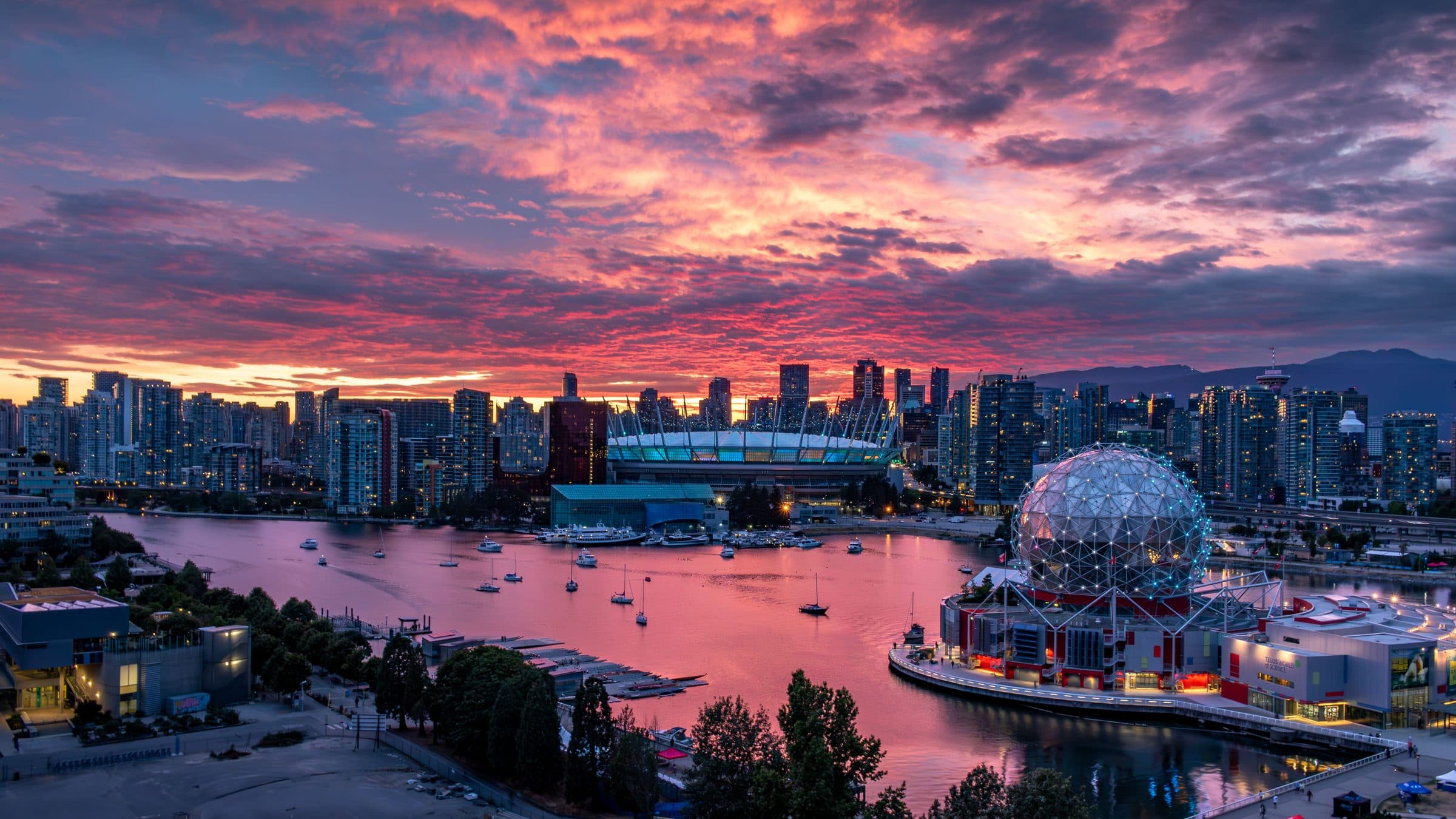 Vista da cidade de Vancouver ao pôr do sol com o céu colorido refletido na água do porto