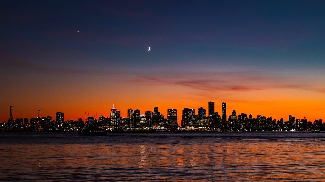 Vista panorâmica da cidade de Vancouver no Canadá ao crepúsculo com a lua no céu