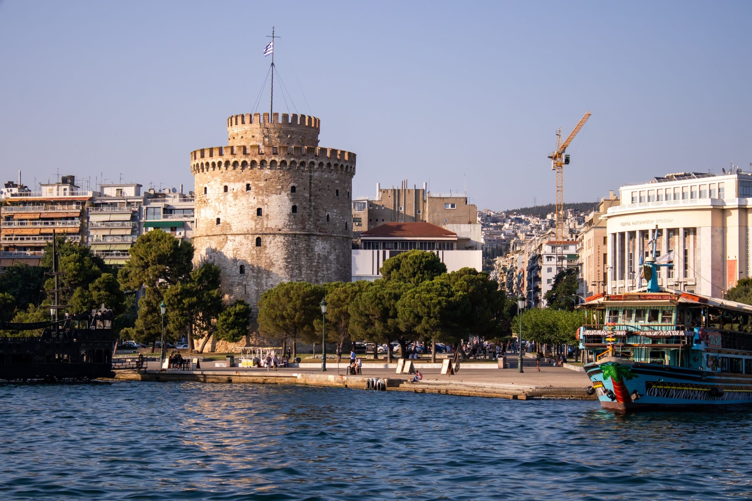 Torre Branca na orla de Thessaloniki com barcos na água e prédios da cidade ao fundo
