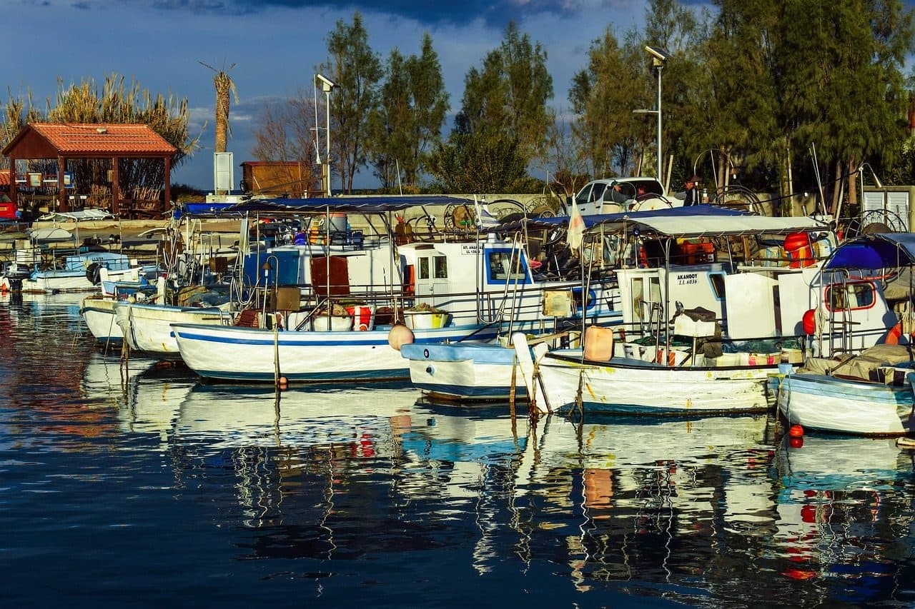 Barcos no porto de pesca de Ayia Triada, em Paralimni, com reflexos no mar