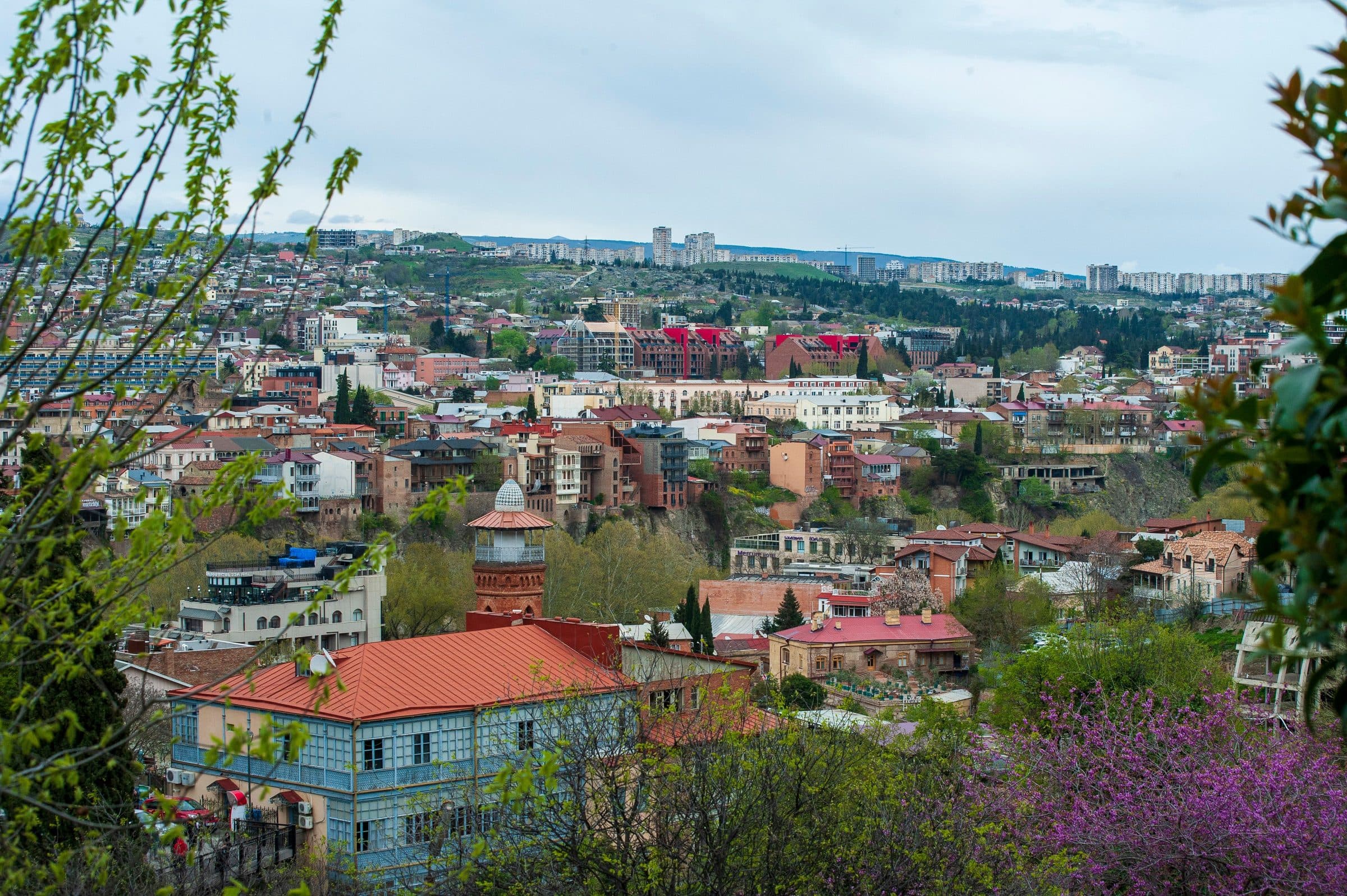 Paisagem urbana de Tbilisi, na Geórgia, com áreas verdes e arquitetura tradicional
