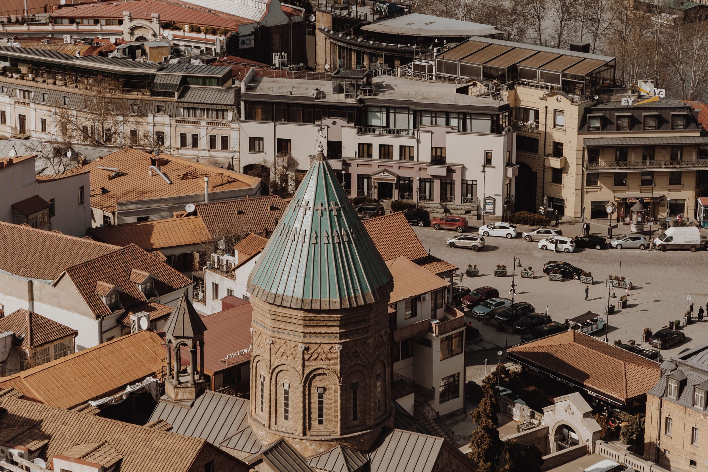 Vista aérea do centro histórico de Tbilisi com arquitetura antiga e movimento urbano