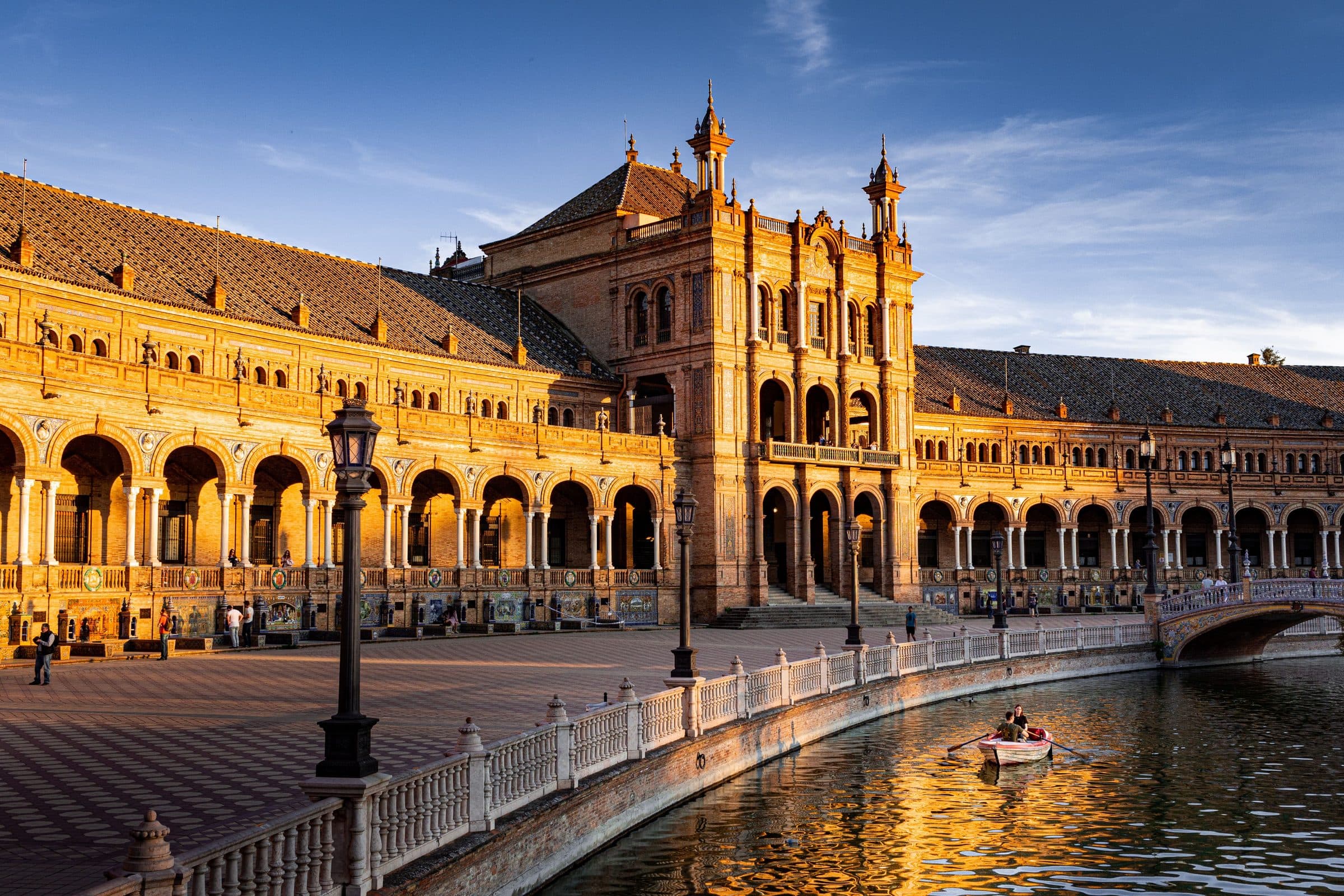 Plaza de España em Sevilha ao pôr do sol com reflexos da arquitetura no canal