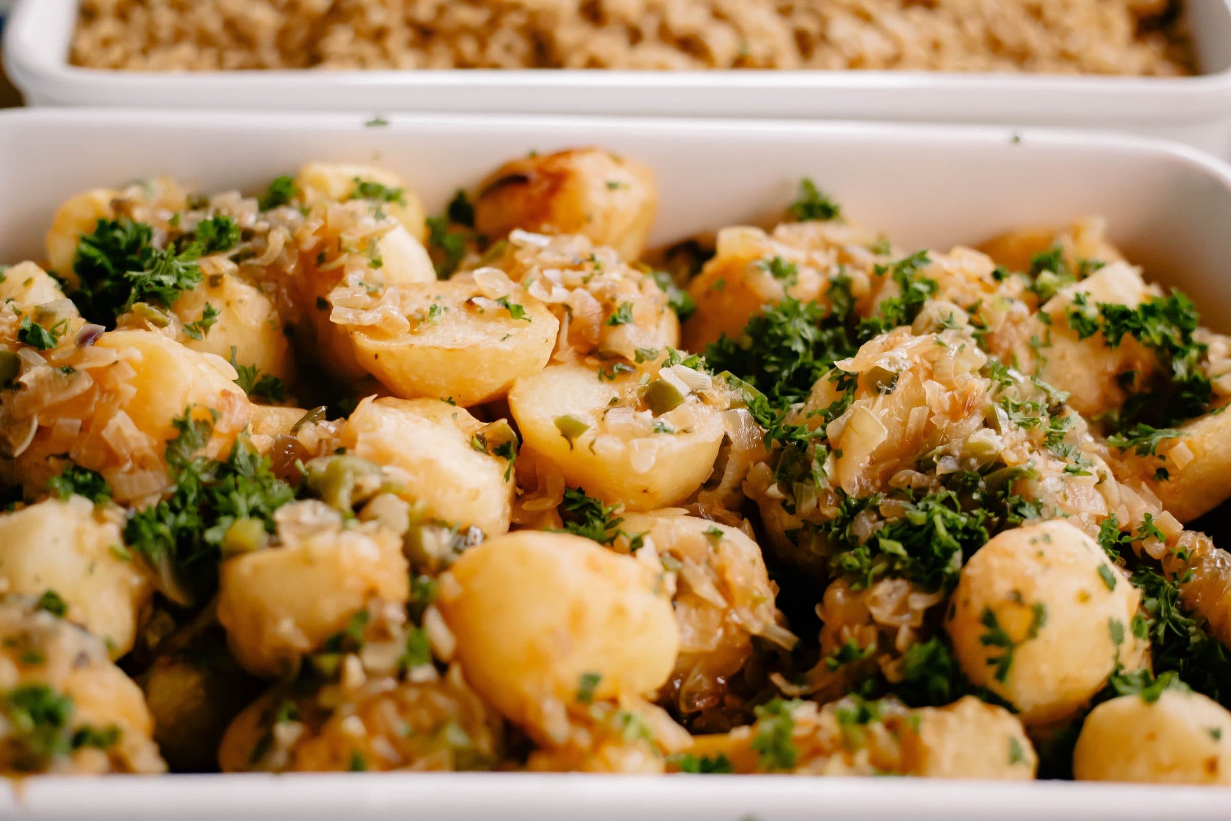 Close-up de batatas temperadas e salpicadas com salsa fresca