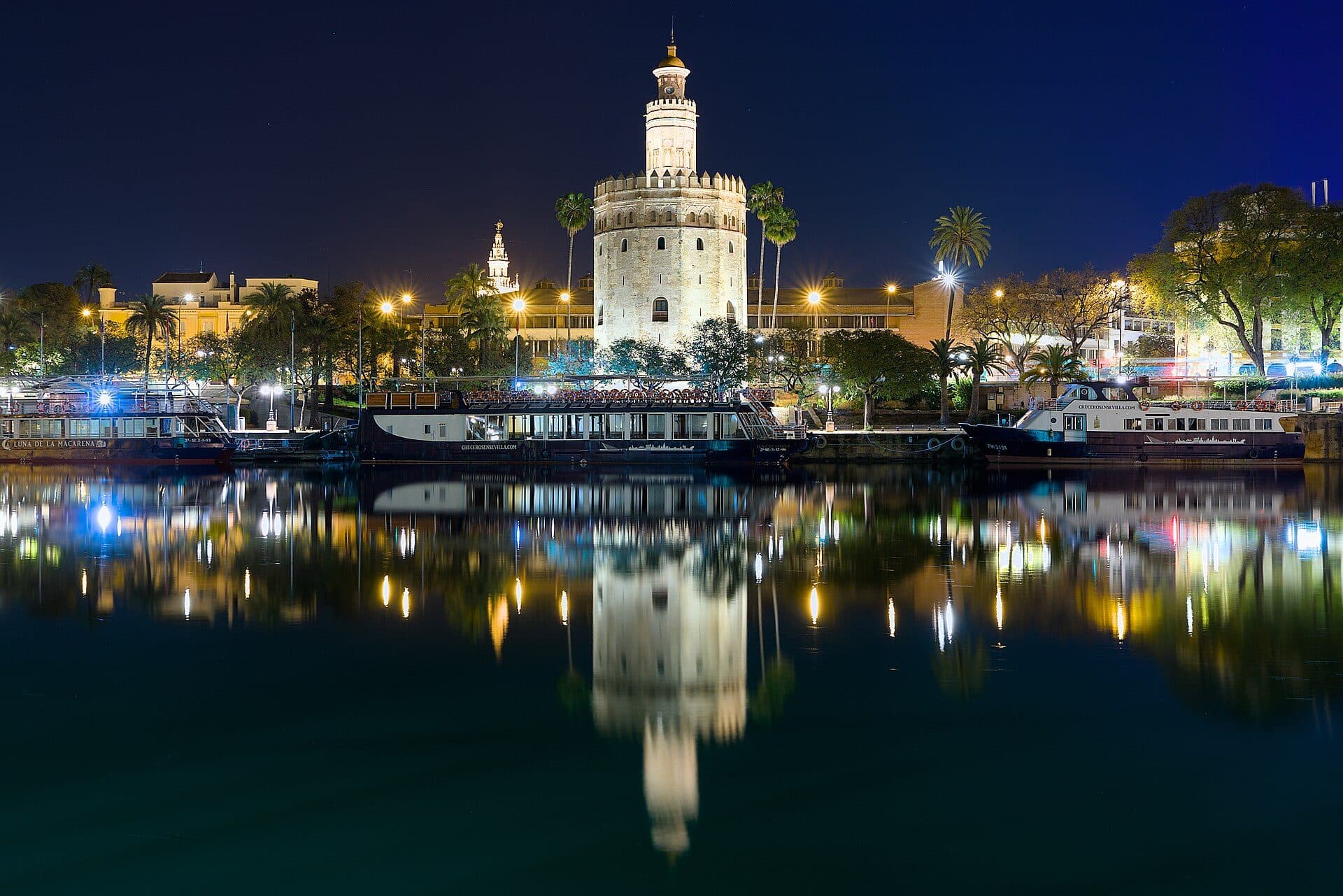 Vista noturna da Torre del Oro e do rio Guadalquivir em Sevilha