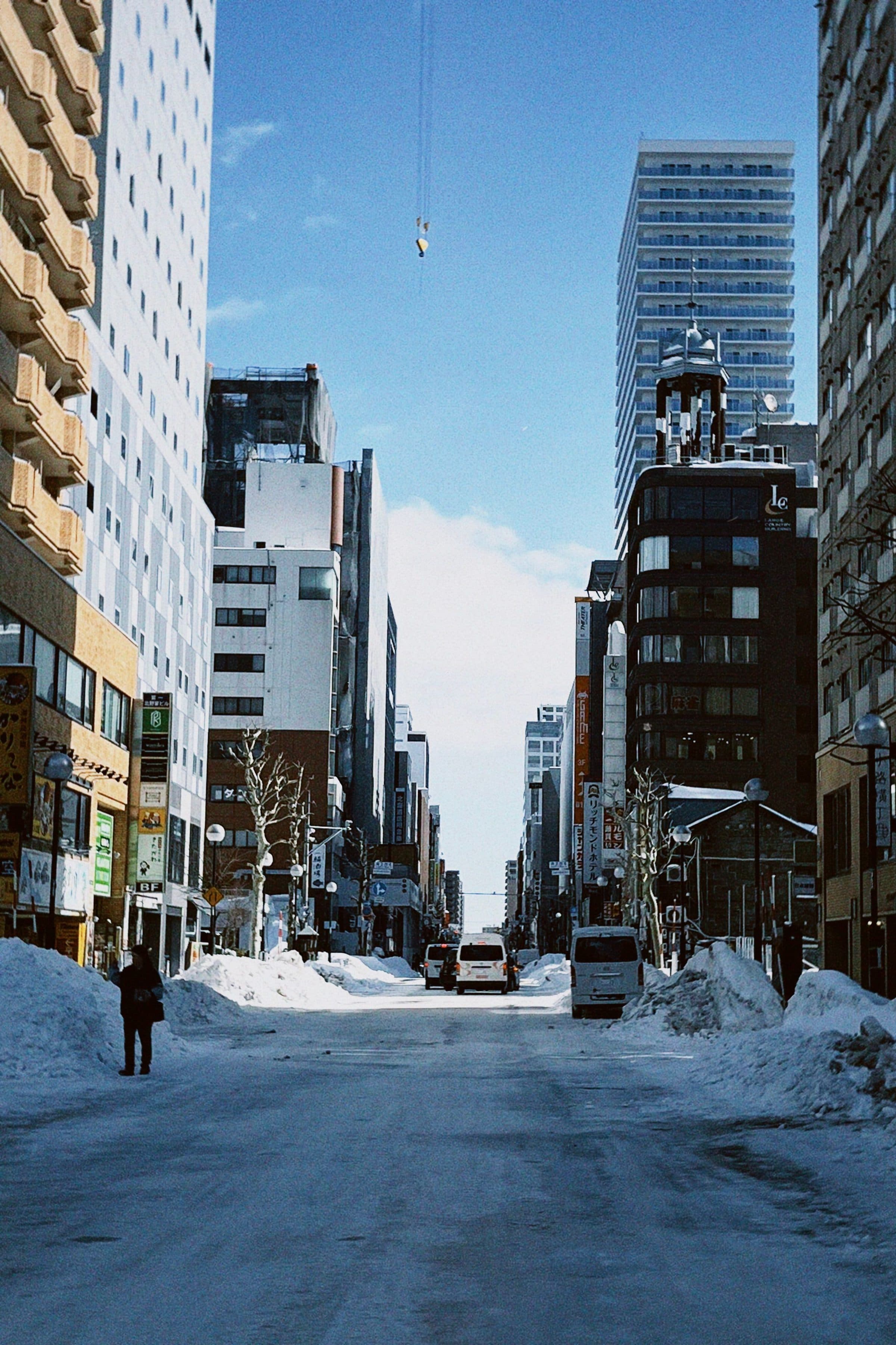 Rua urbana coberta de neve em Sapporo, no Japão, em um dia claro de inverno