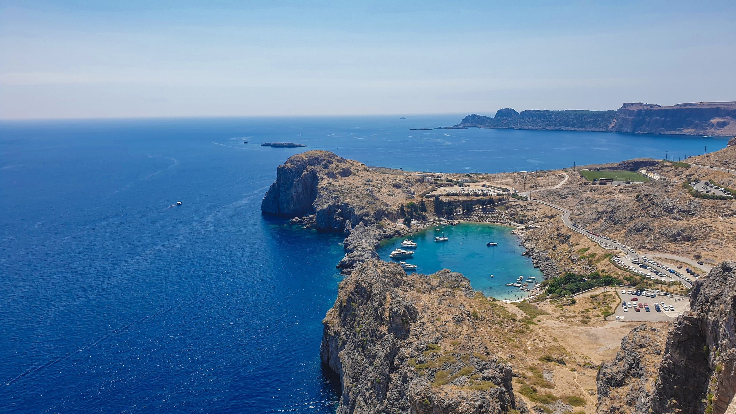 Vista aérea de St. Paul's Bay em Rhodes com águas azul-turquesa e penhascos rochosos