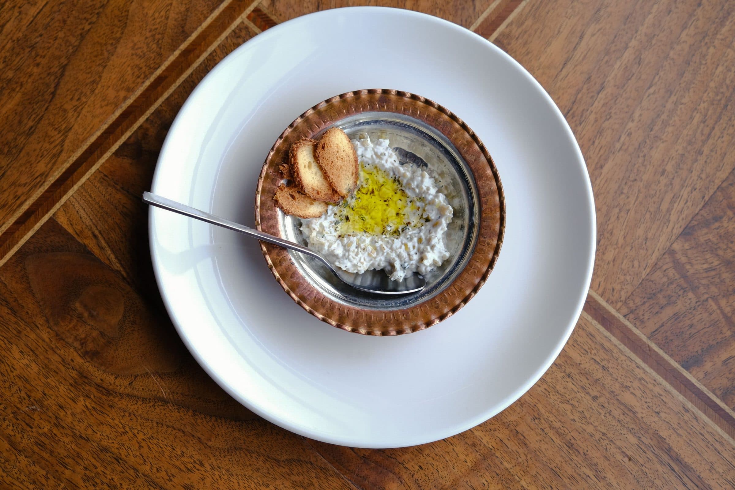 Vista superior de prato de mezze turco com azeite de oliva e biscoitos sobre mesa de madeira