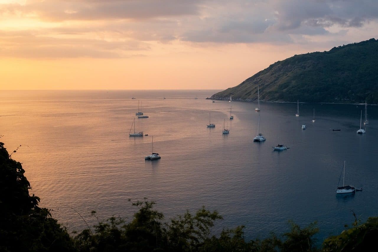 Iates ancorados em uma baía em Phuket durante o pôr do sol