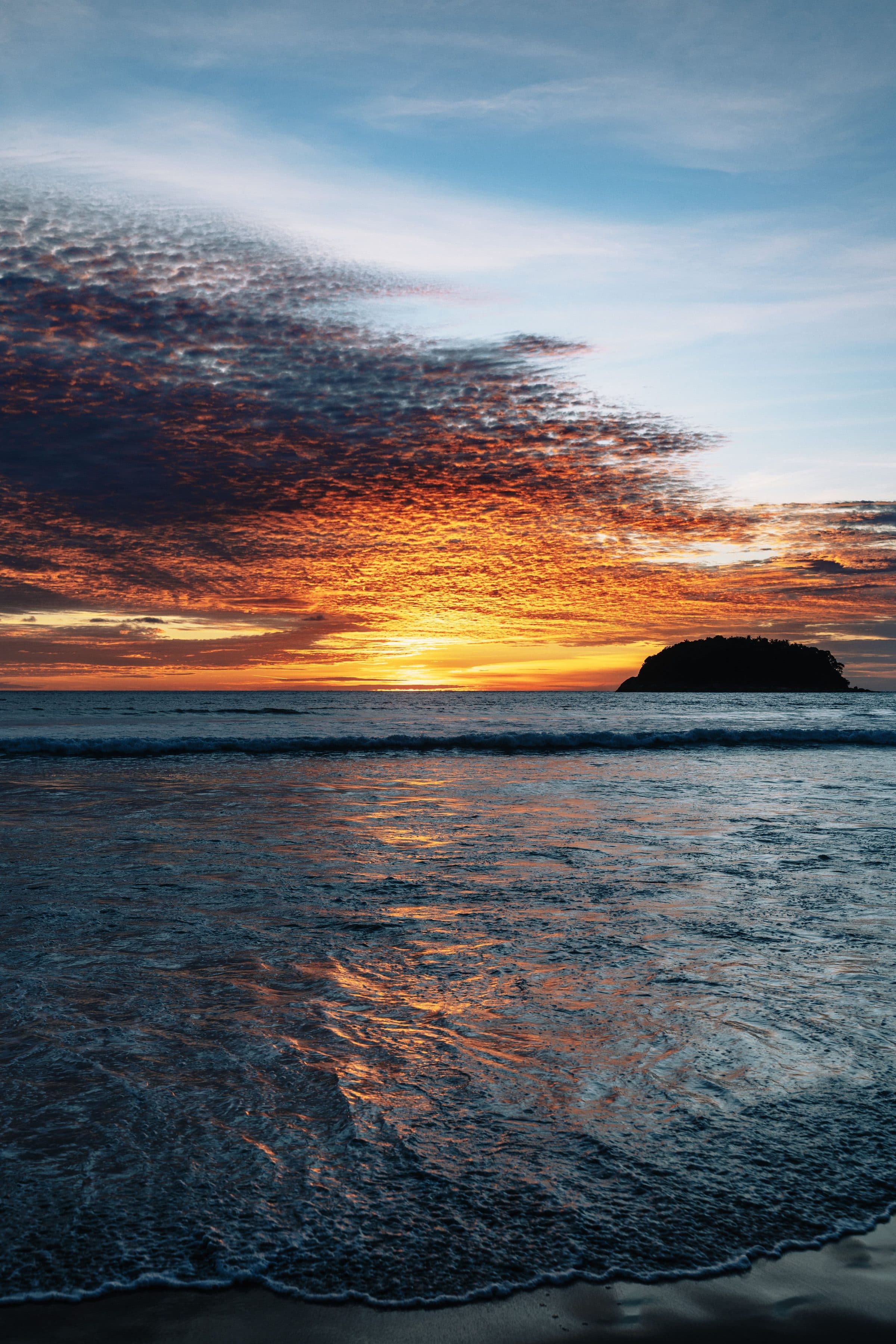 Pôr do sol refletindo nas ondas do mar em Kata Beach, Phuket