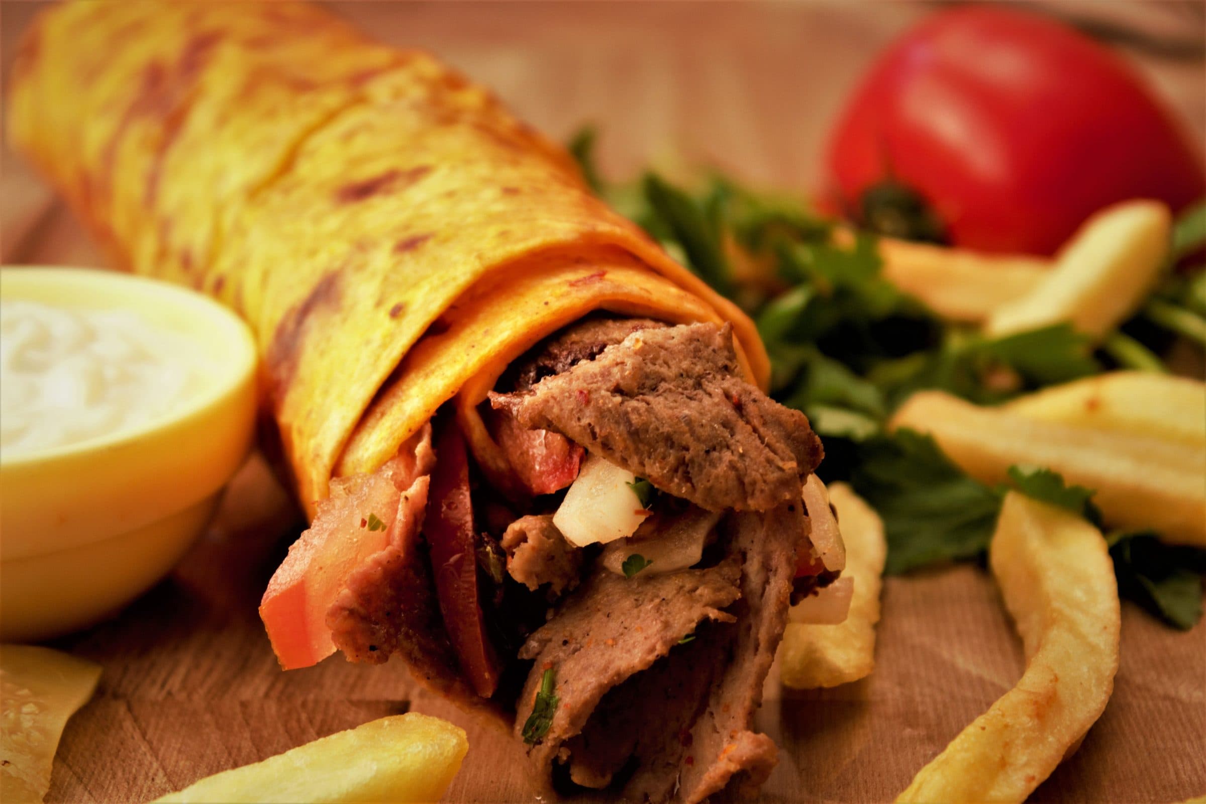 Close-up de wrap de kebab turco servido com batatas fritas e vegetais