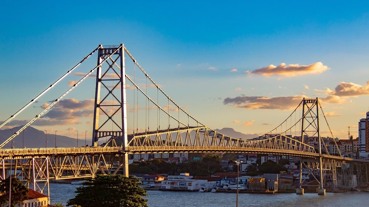 Vista da Ponte Hercílio Luz sobre o mar durante o pôr do sol em Florianópolis