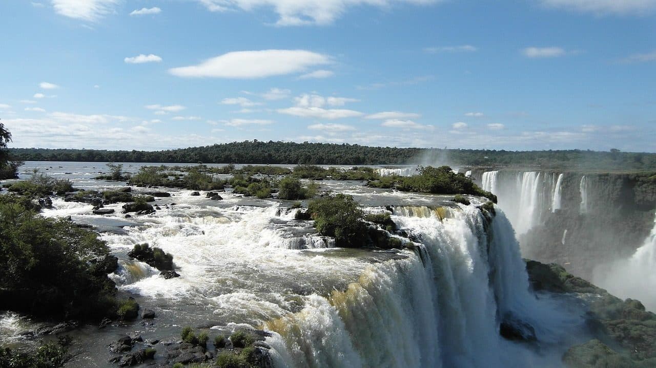 Vista das quedas d'água das Cataratas do Iguaçu com névoa e vegetação natural