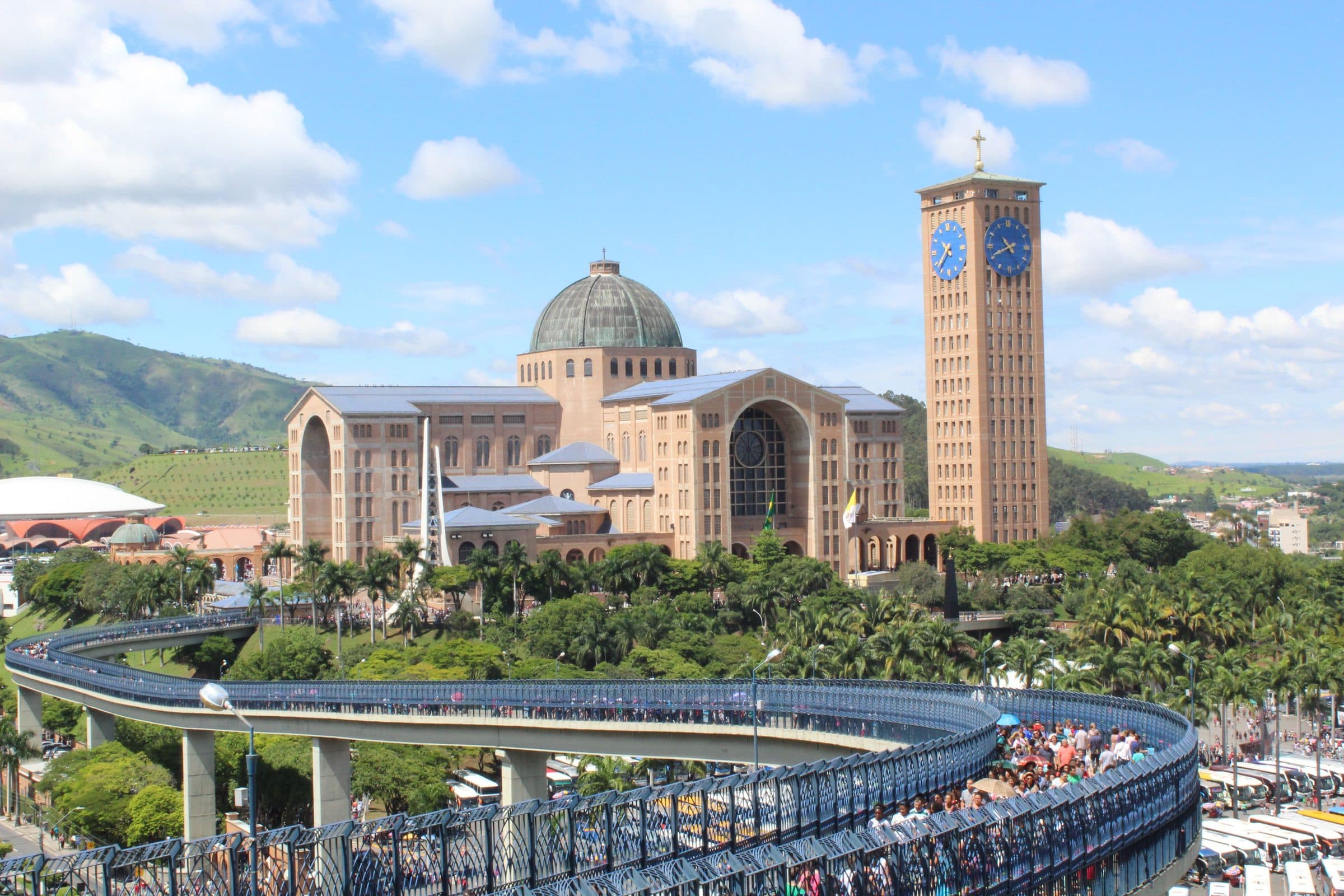 Vista panorâmica da Basílica de Nossa Senhora Aparecida cercada por vegetação e colinas
