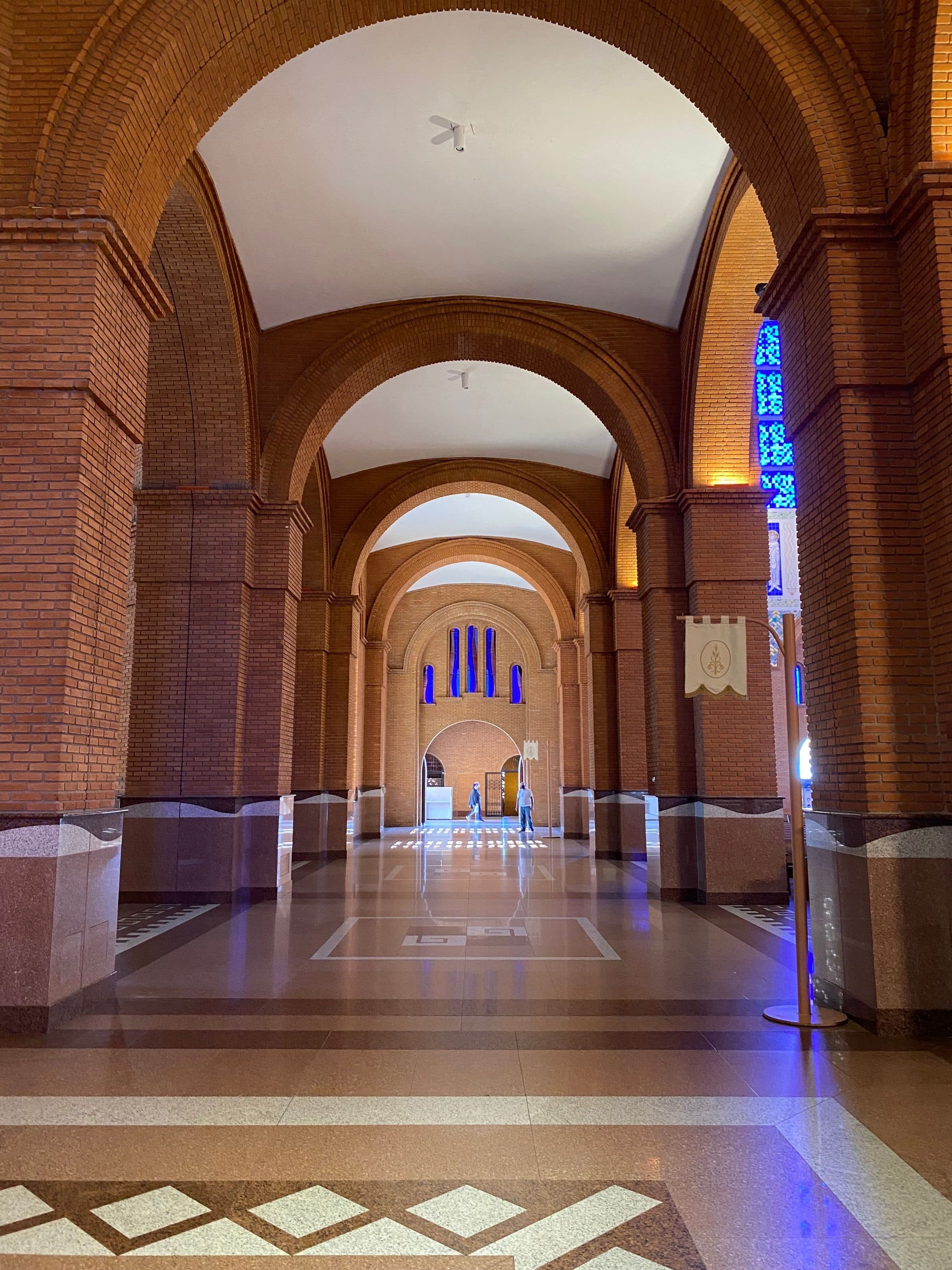 Vista do interior da Basílica de Aparecida com seus grandes arcos e vitrais