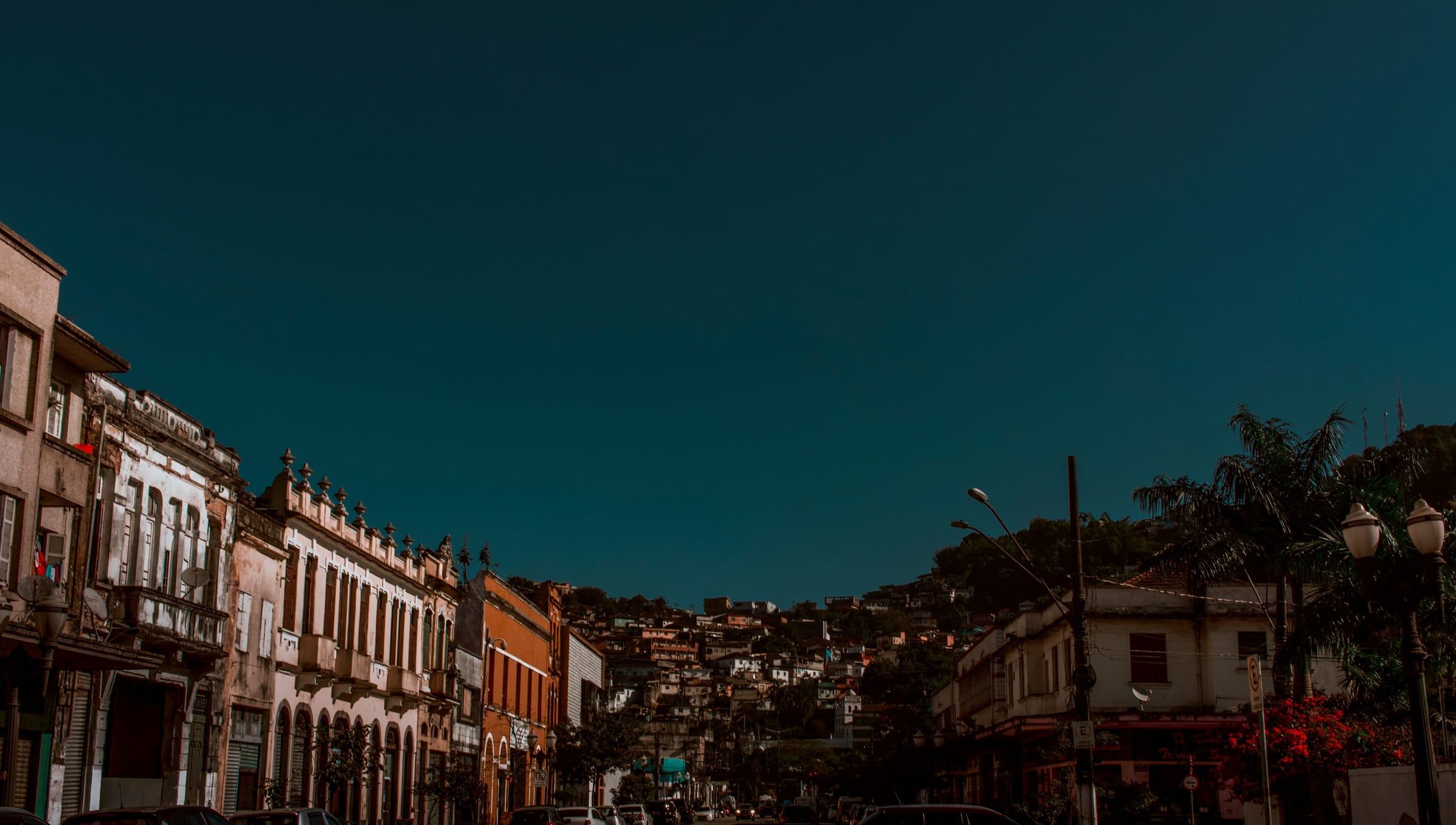 Vista de rua com edifícios tradicionais sob céu azul em Santos, SP