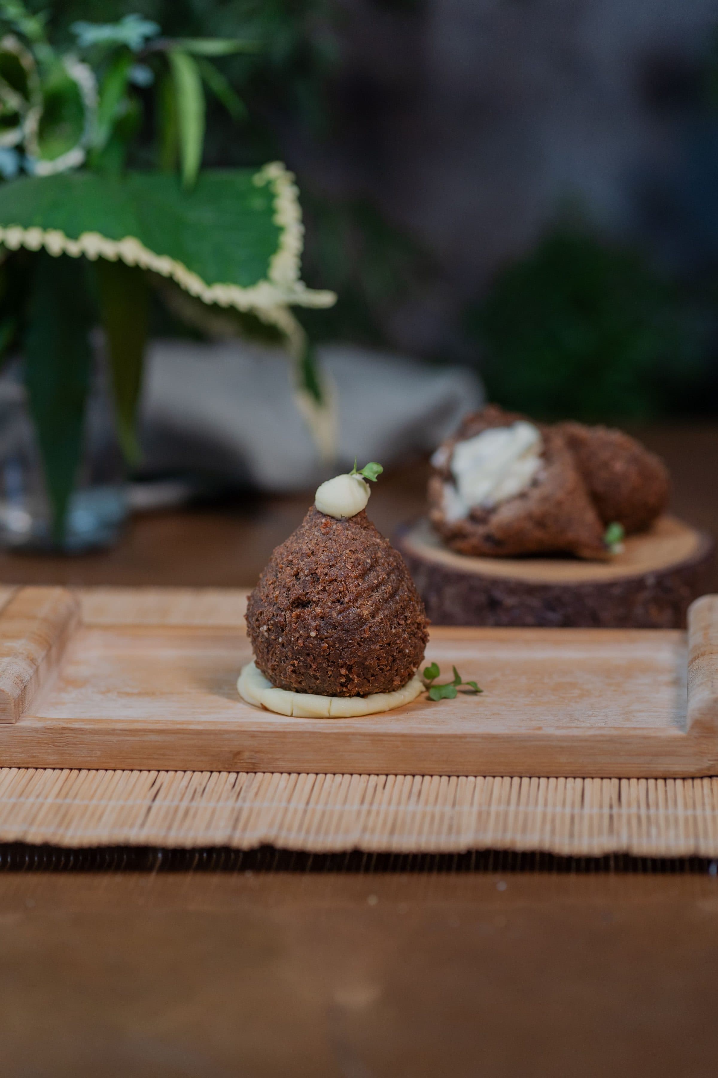 Bolinhos de falafel servidos em uma travessa de madeira com ervas frescas