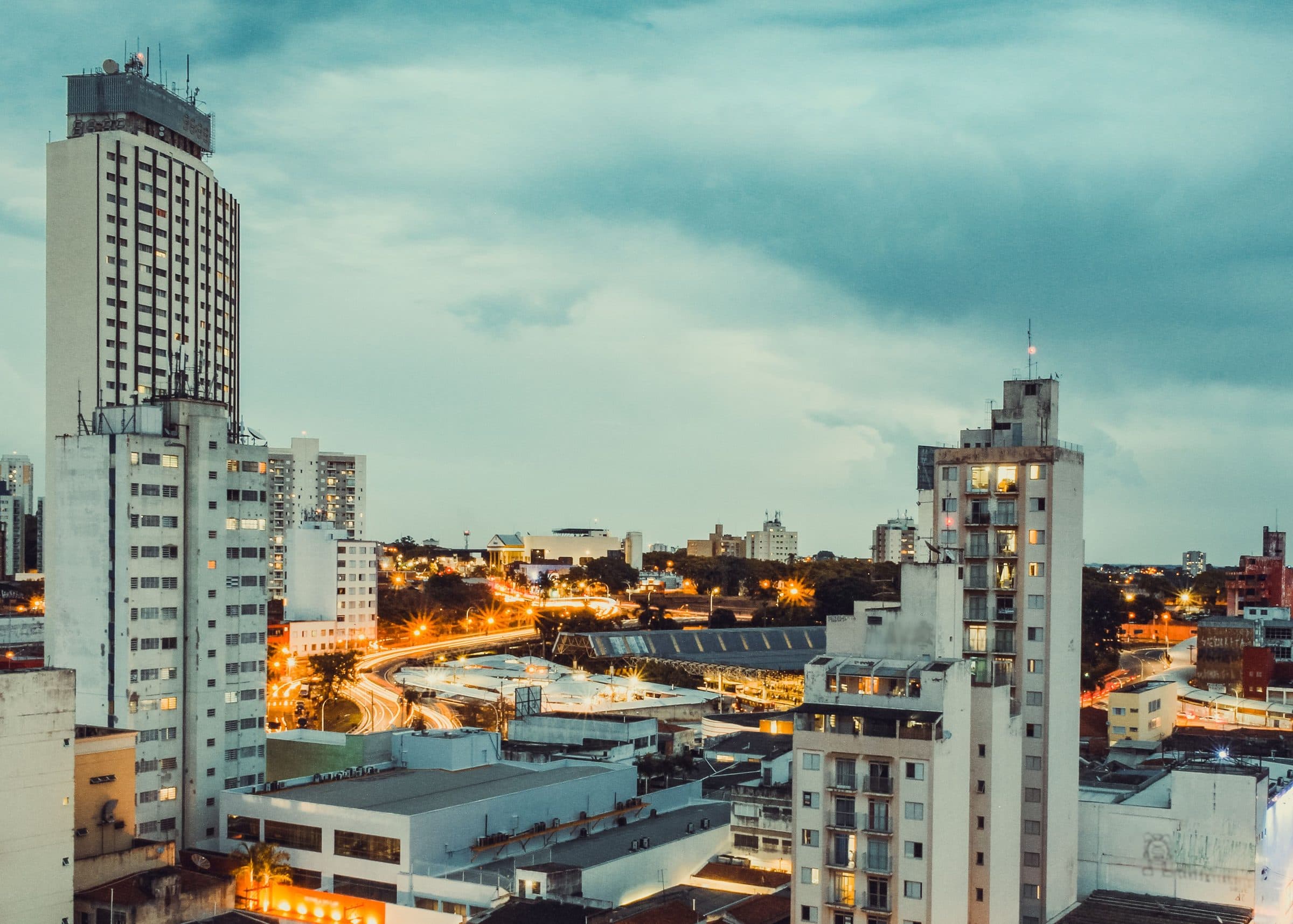 Vista da cidade de Campinas com arranha-céus iluminados ao entardecer