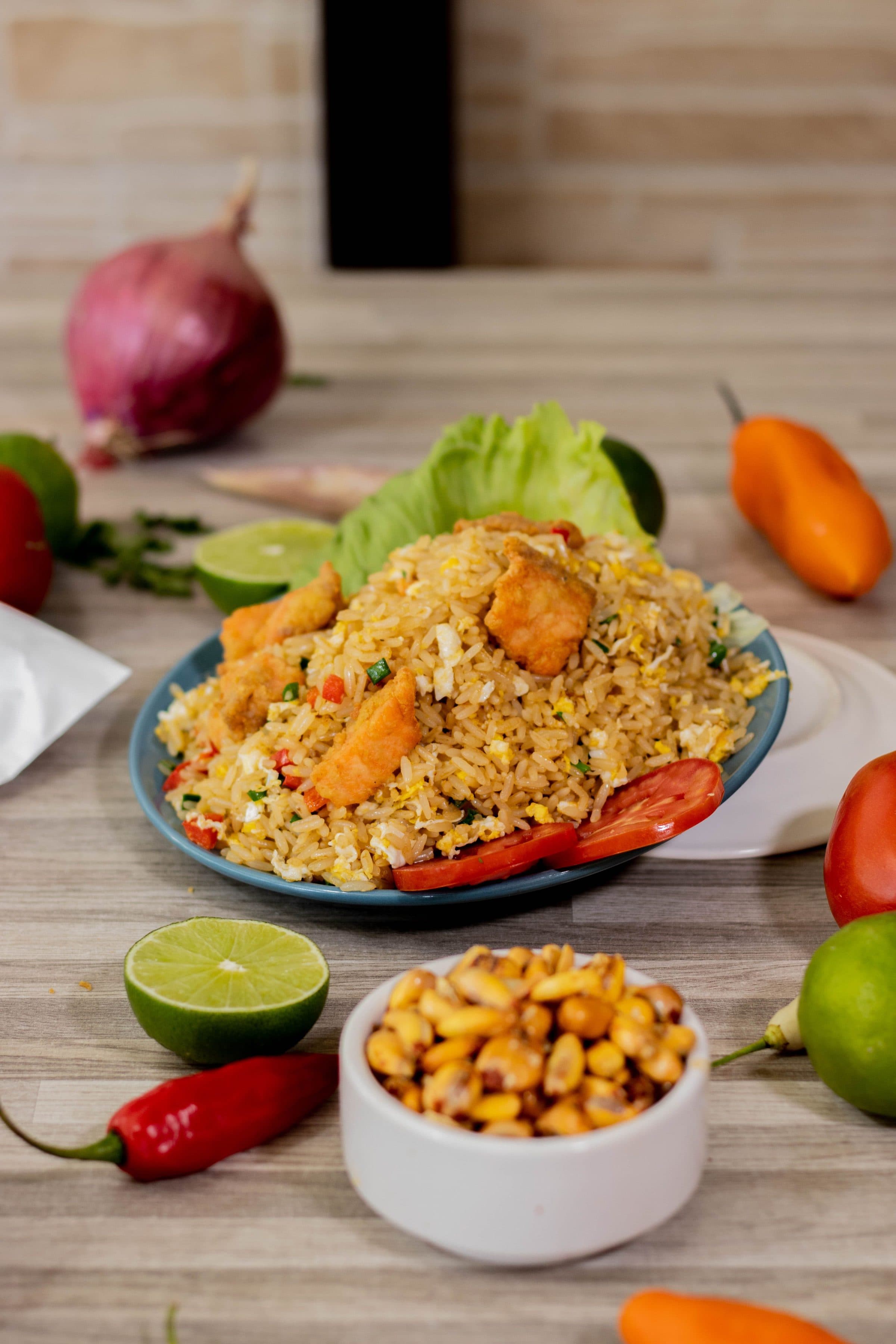Prato de arroz chaufa peruano preparado com frango, pimentões e limão